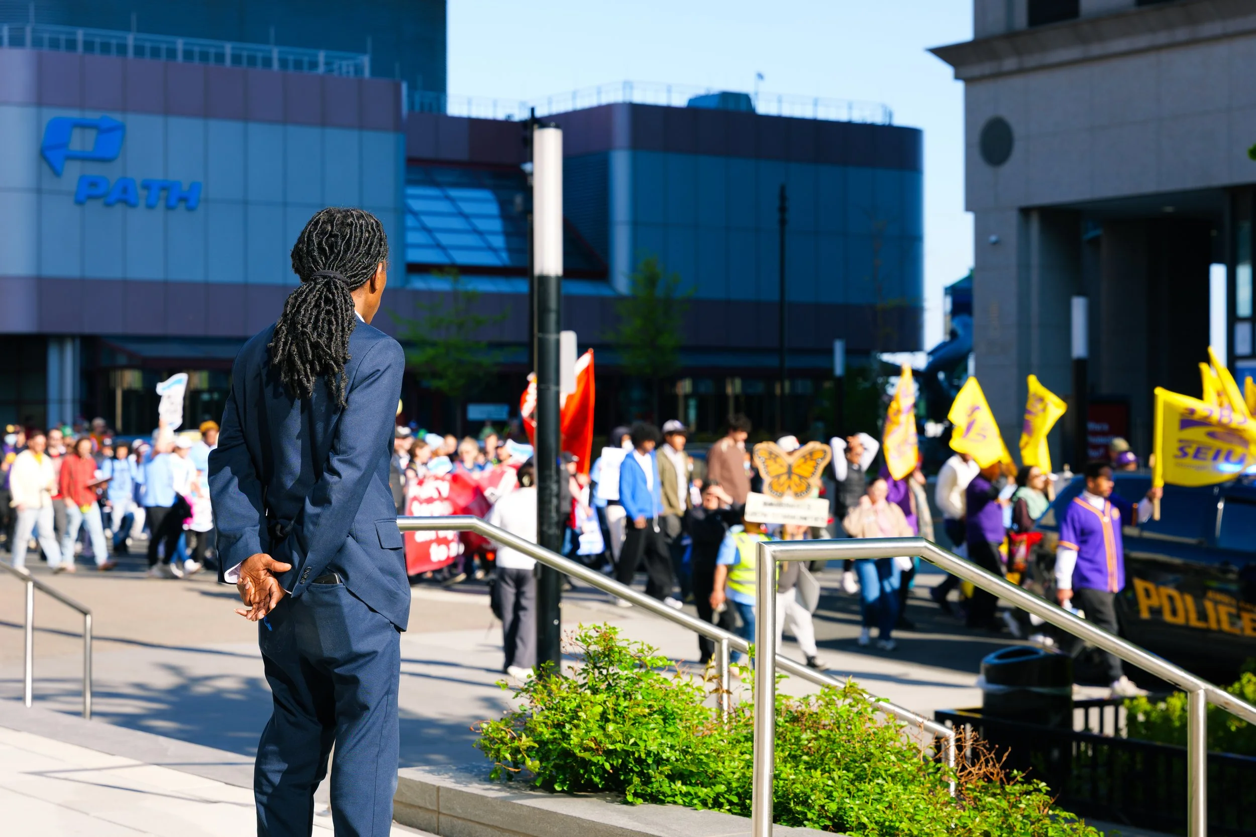 A security guard watches as marchers pass by near the NJPATH station in downtown Jersey City