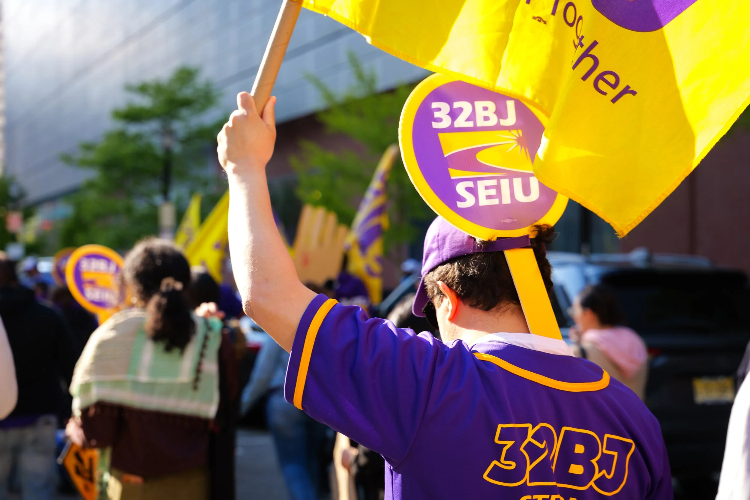 A member of 32BJ SEIU marches with protestors
