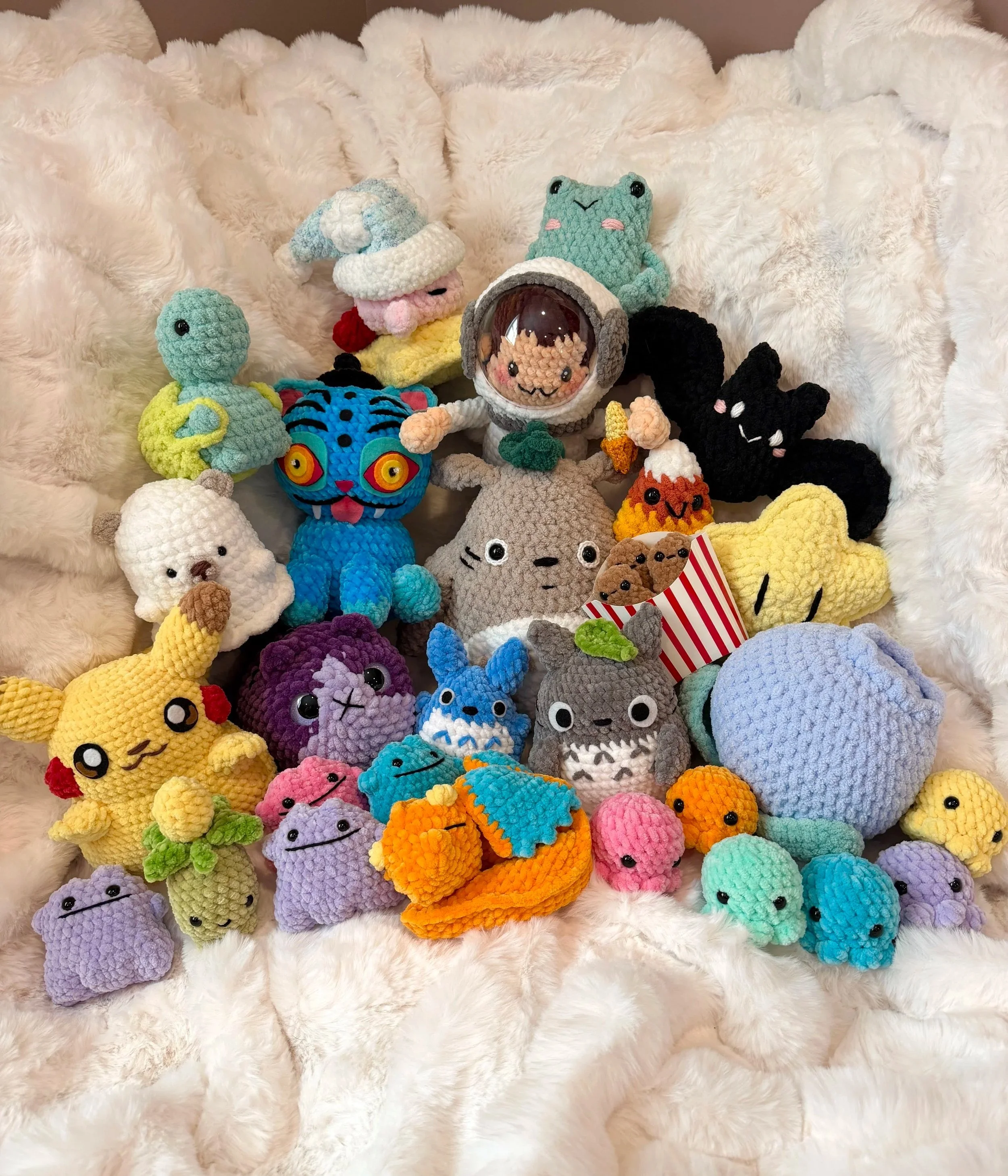 collection of a variety of colorful crochet plushies all varying in size and themes including videogames, movies, holidays, and different animals