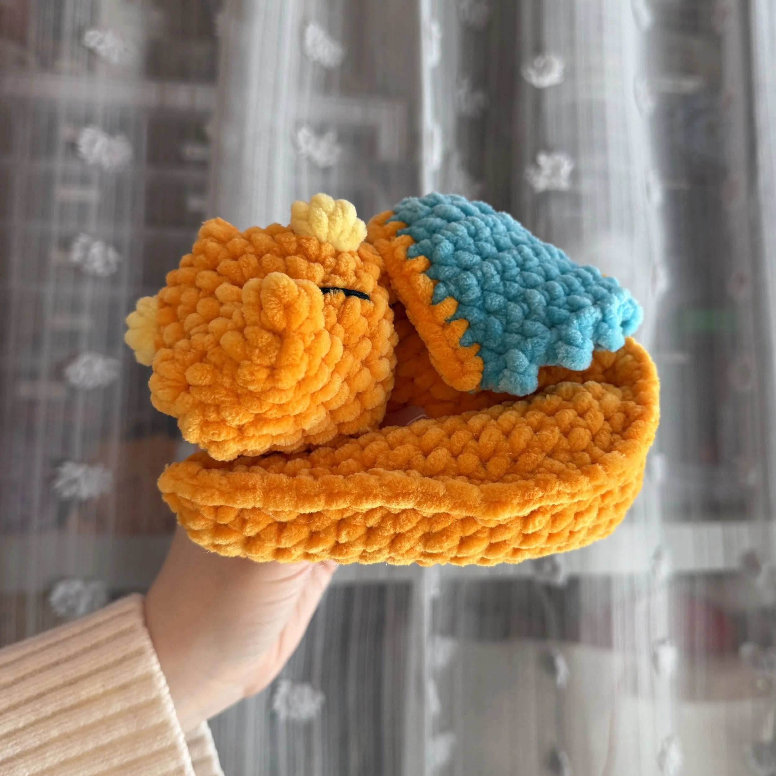 crochet sleepy orange dragon curled up