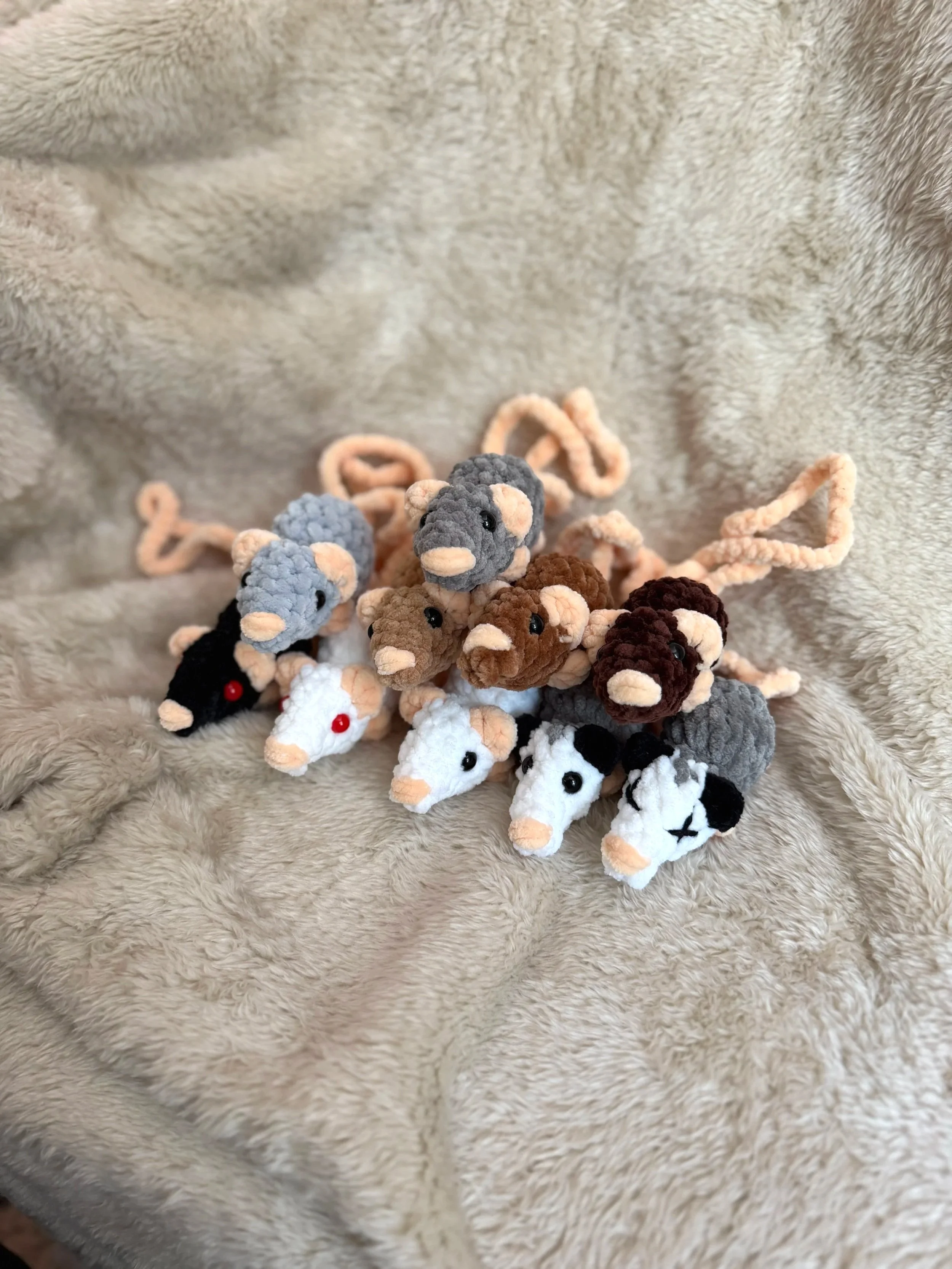 pile of crochet rat and opossum bag charms