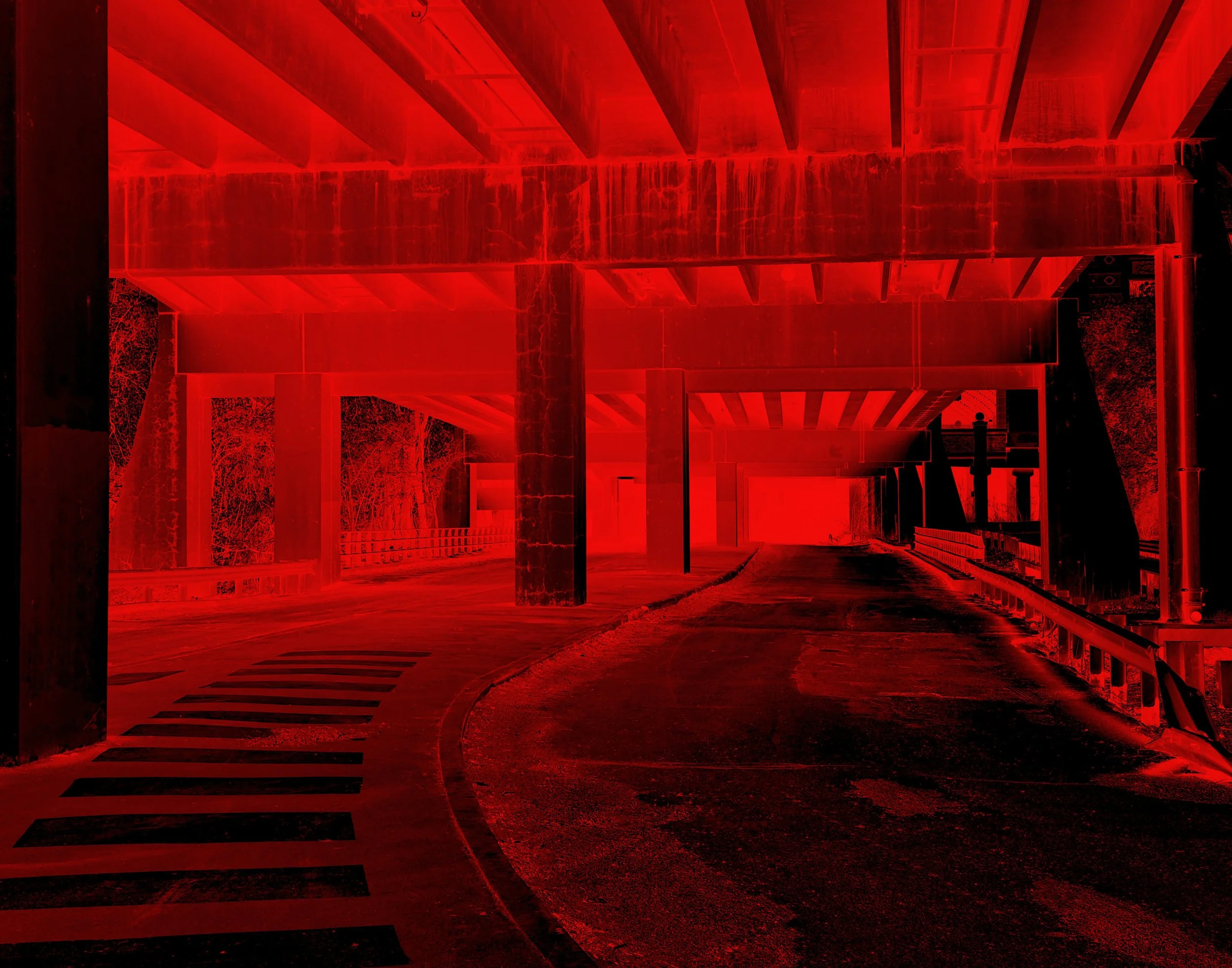 A red-lit view of an underside of a bridge with concrete pillars and railroad tracks overhead, with a curved pedestrian crosswalk on the road. Noir inspired fine art photograph