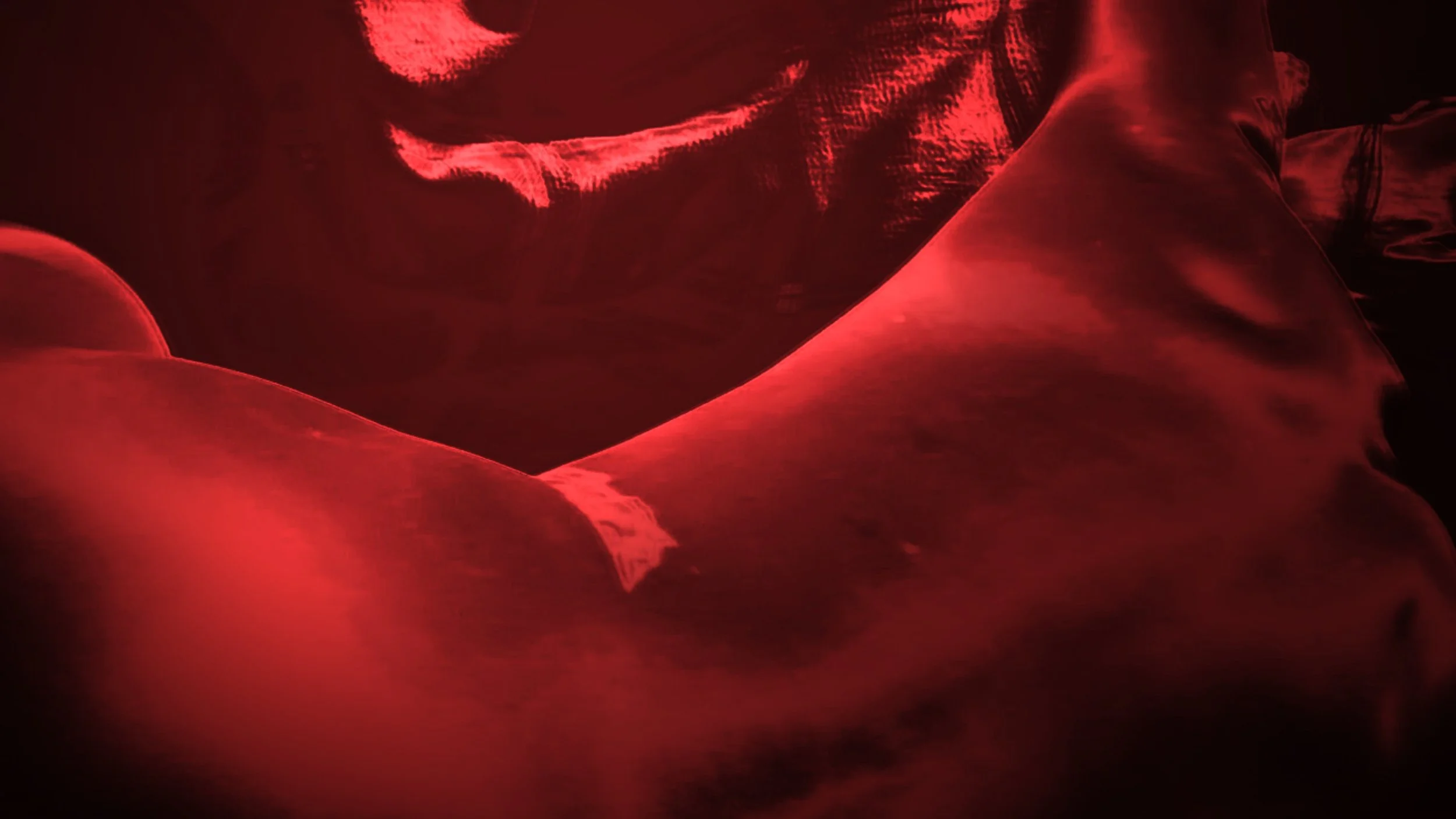 A woman lying on a bed in a dark room illuminated by red lighting, A red aesthetic nude figure photograph featuring a woman in an erotic pose, with red lighting.