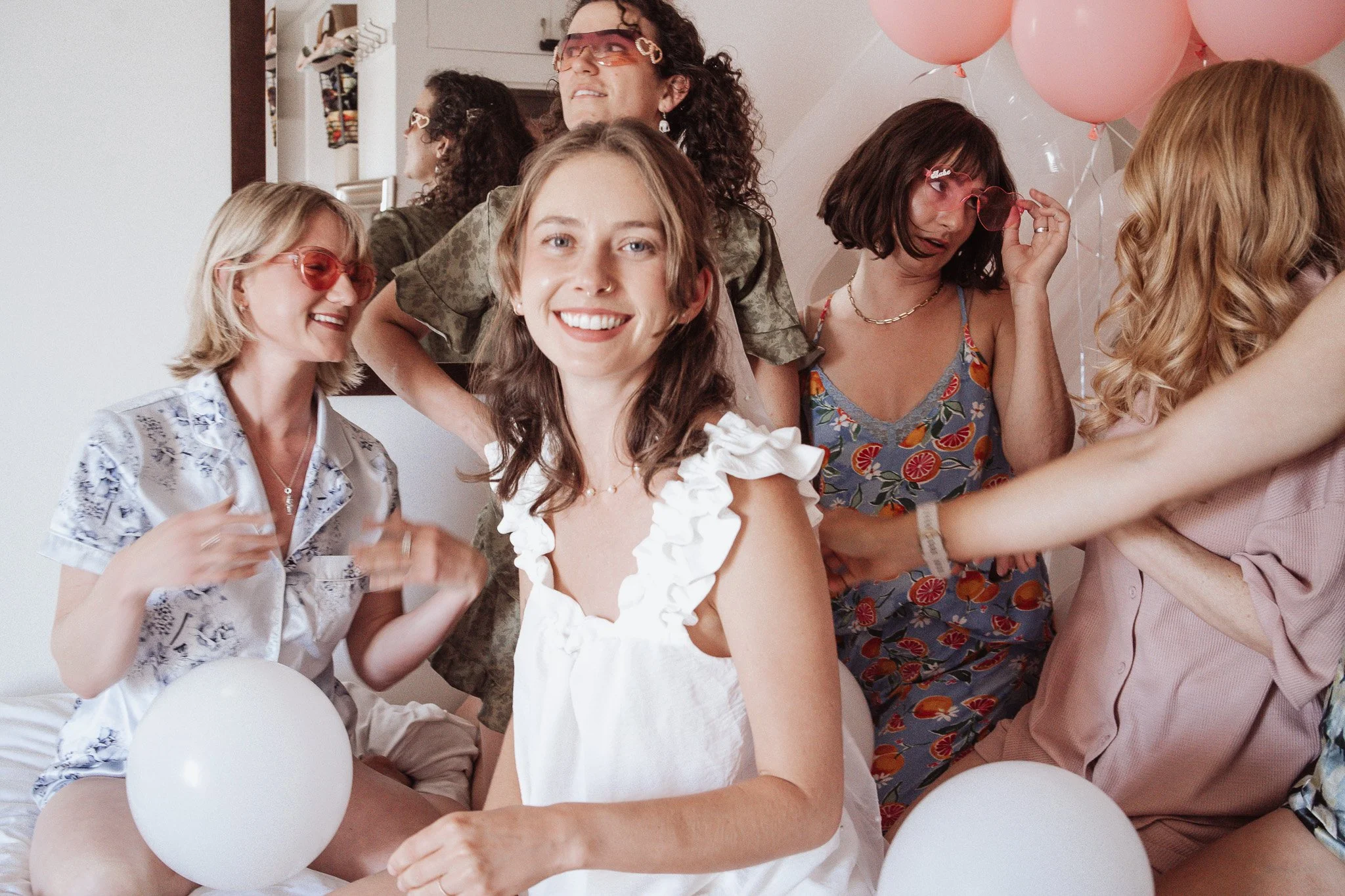 Bachelorette party Santa Barbara. A group of women celebrating with pink balloons, dressed in colorful and summery outfits, smiling and enjoying the party.