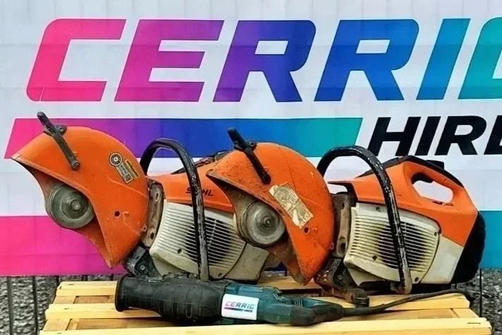 Three orange and white chainsaws on a wooden pallet