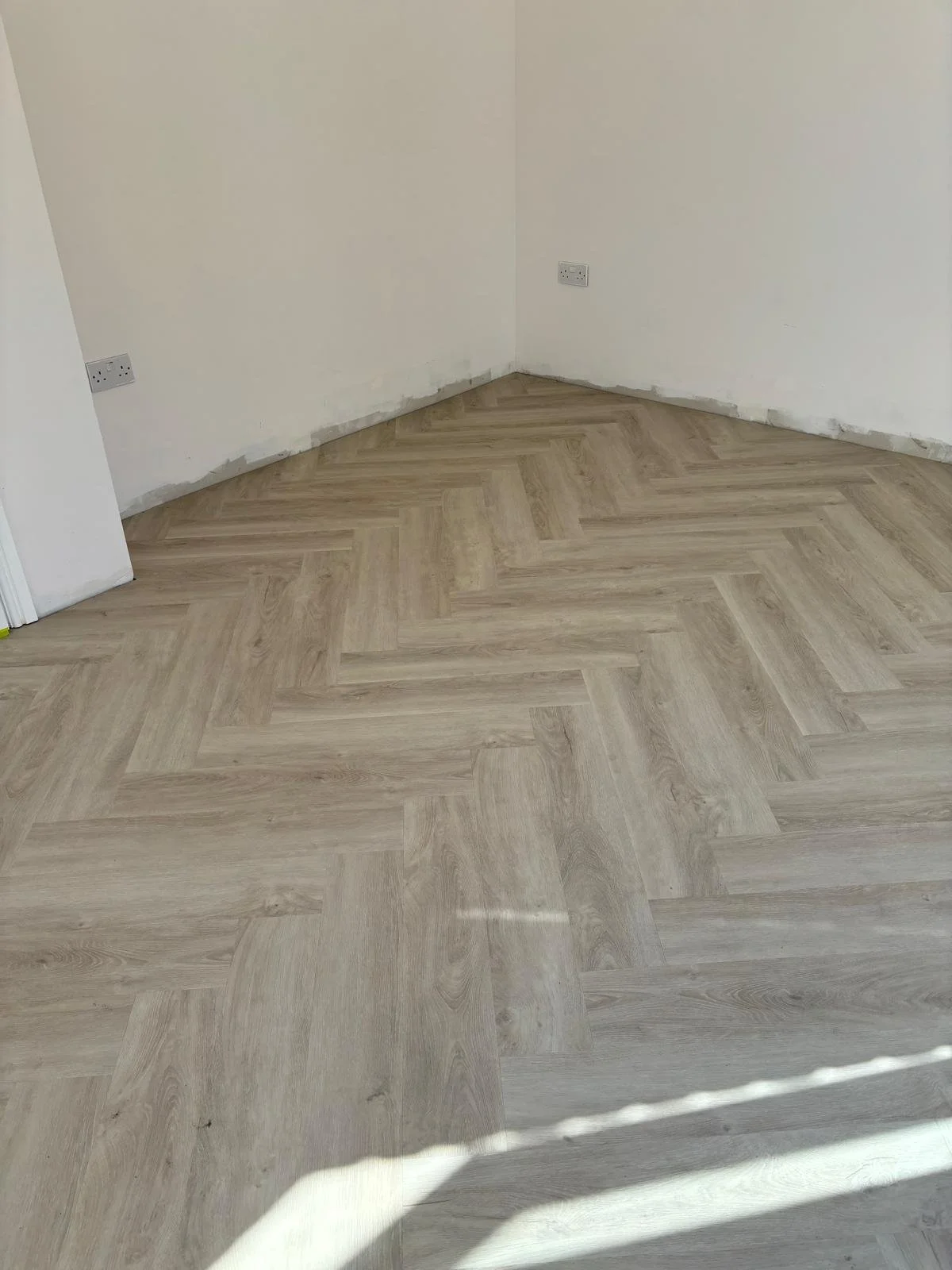 an unfinished looking lacquered herringbone floor
