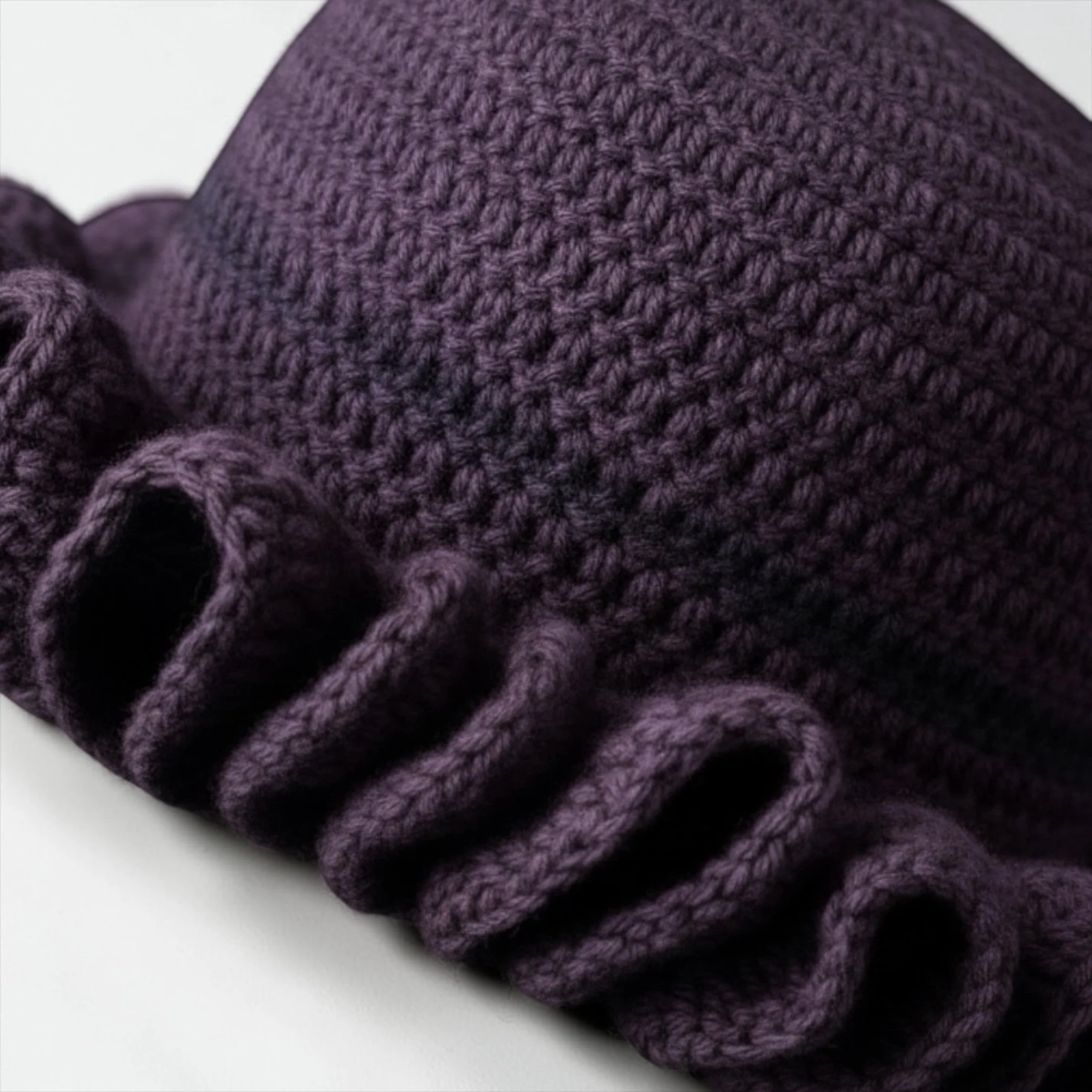Close-up of purple knitted fabric with a textured, woven appearance.