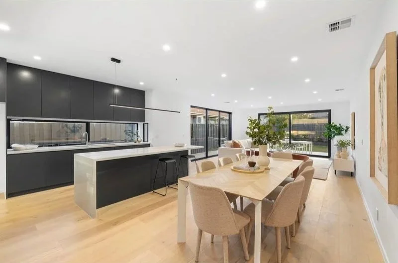 Open-plan kitchen and dining with stone island and timber floors, Bentleigh townhouse