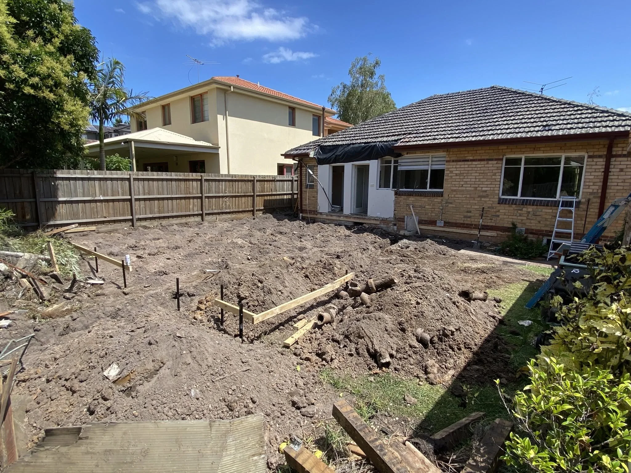 Site set-out for the McKinnon extension, with the old structure removed and stakes and string lines marking the new footprint