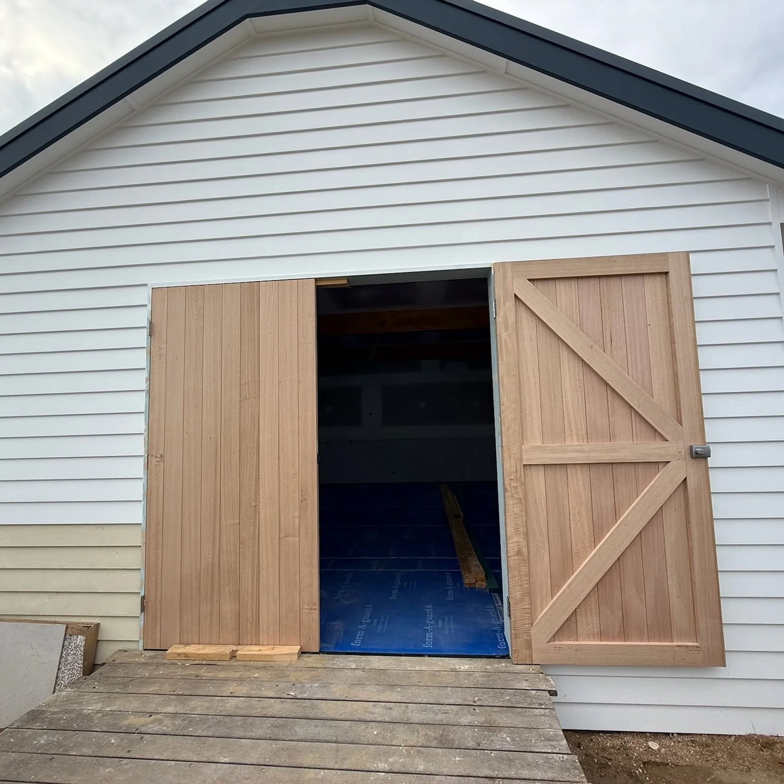 Hand-built timber ledge and brace doors, beach boatshed rebuild