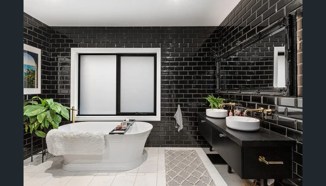 Black-tiled bathroom with freestanding bath and twin basins, Highett renovation