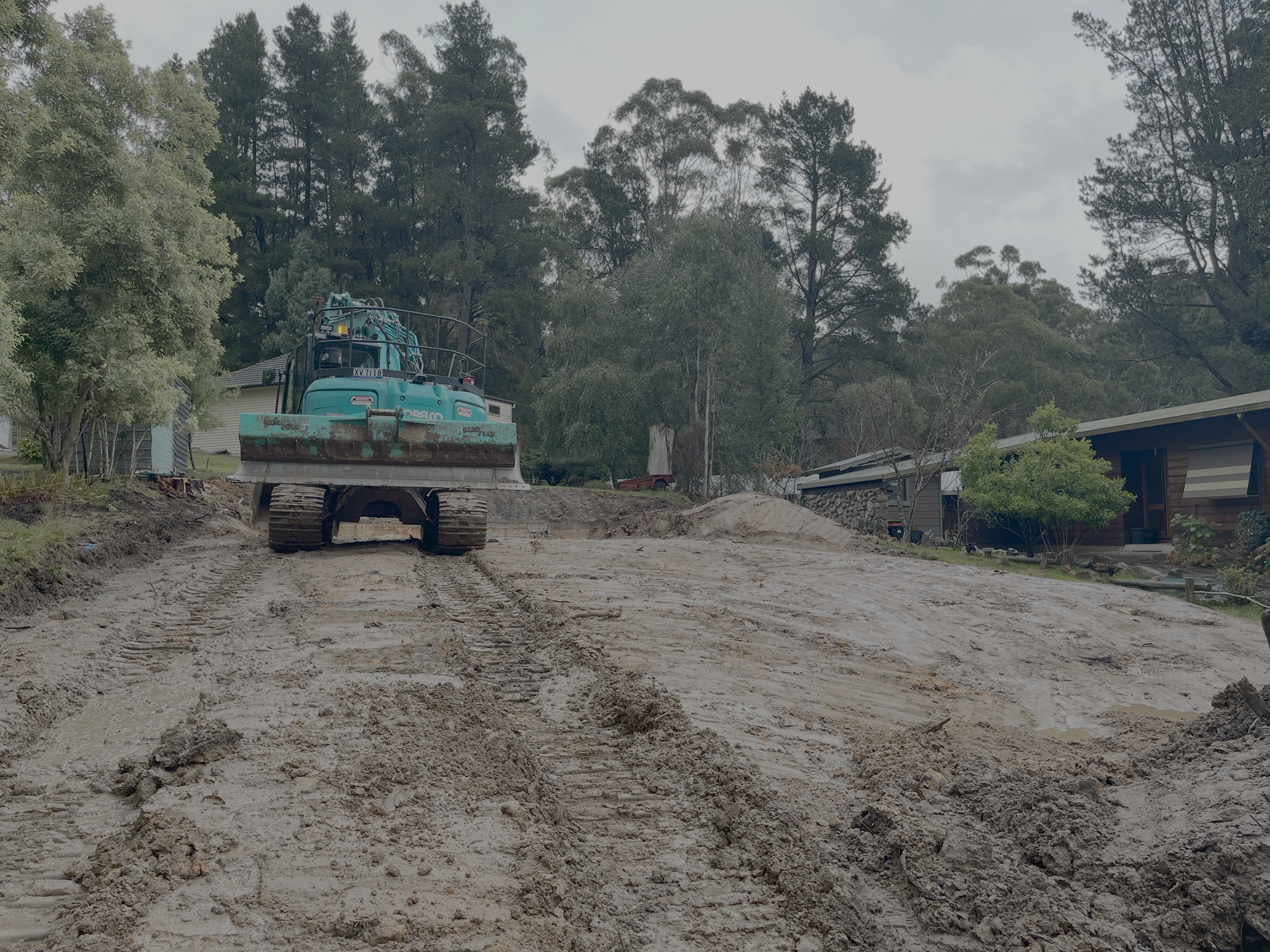 Excavator clearing and levelling the bush block for the Alpine kit home near Mansfield