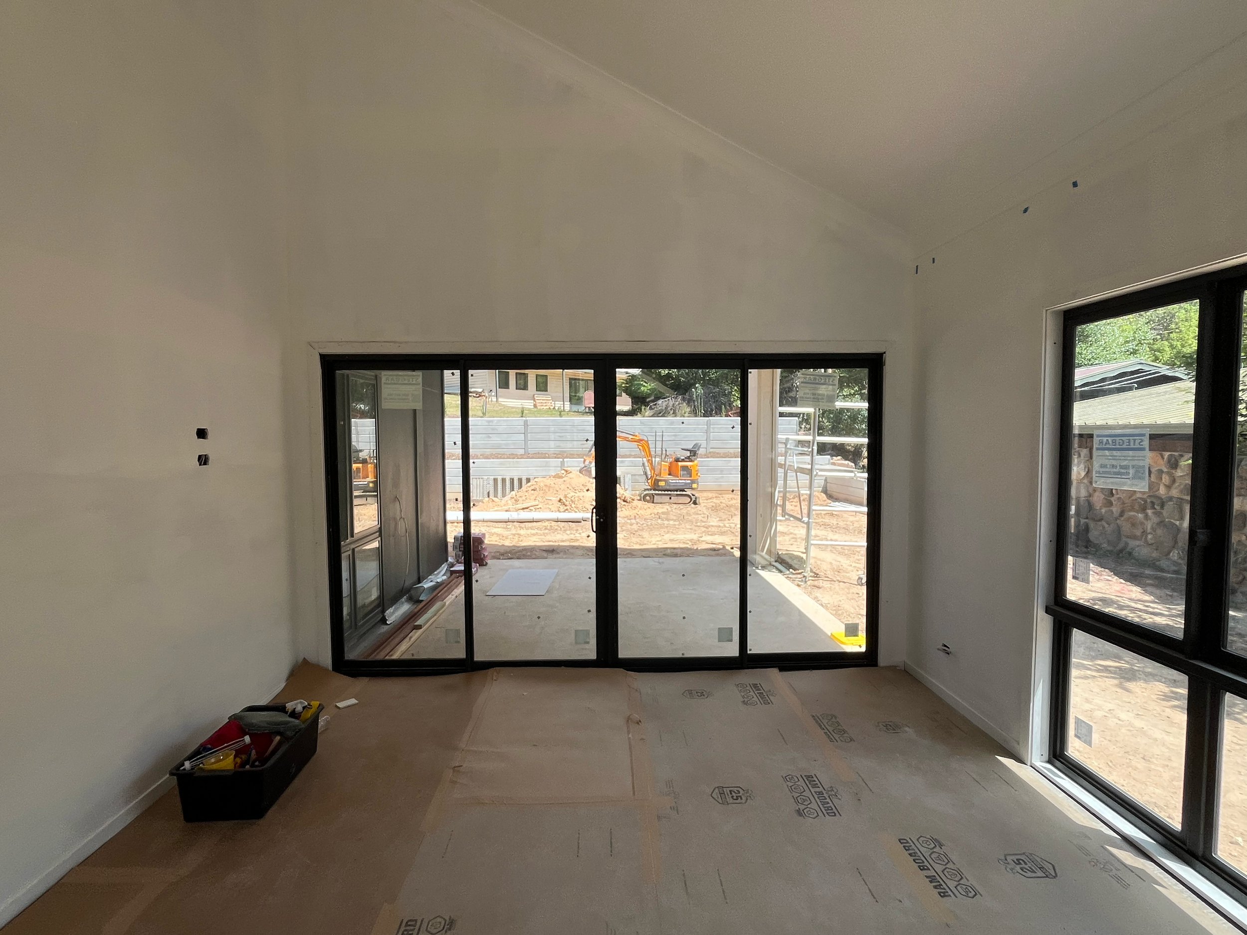 Living area of the Mansfield Alpine home, plastered, with black-framed sliding doors and windows