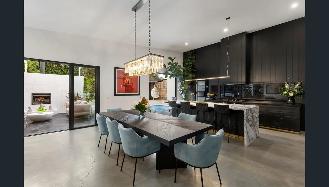 Dining table under a crystal pendant beside the kitchen island, Highett renovation