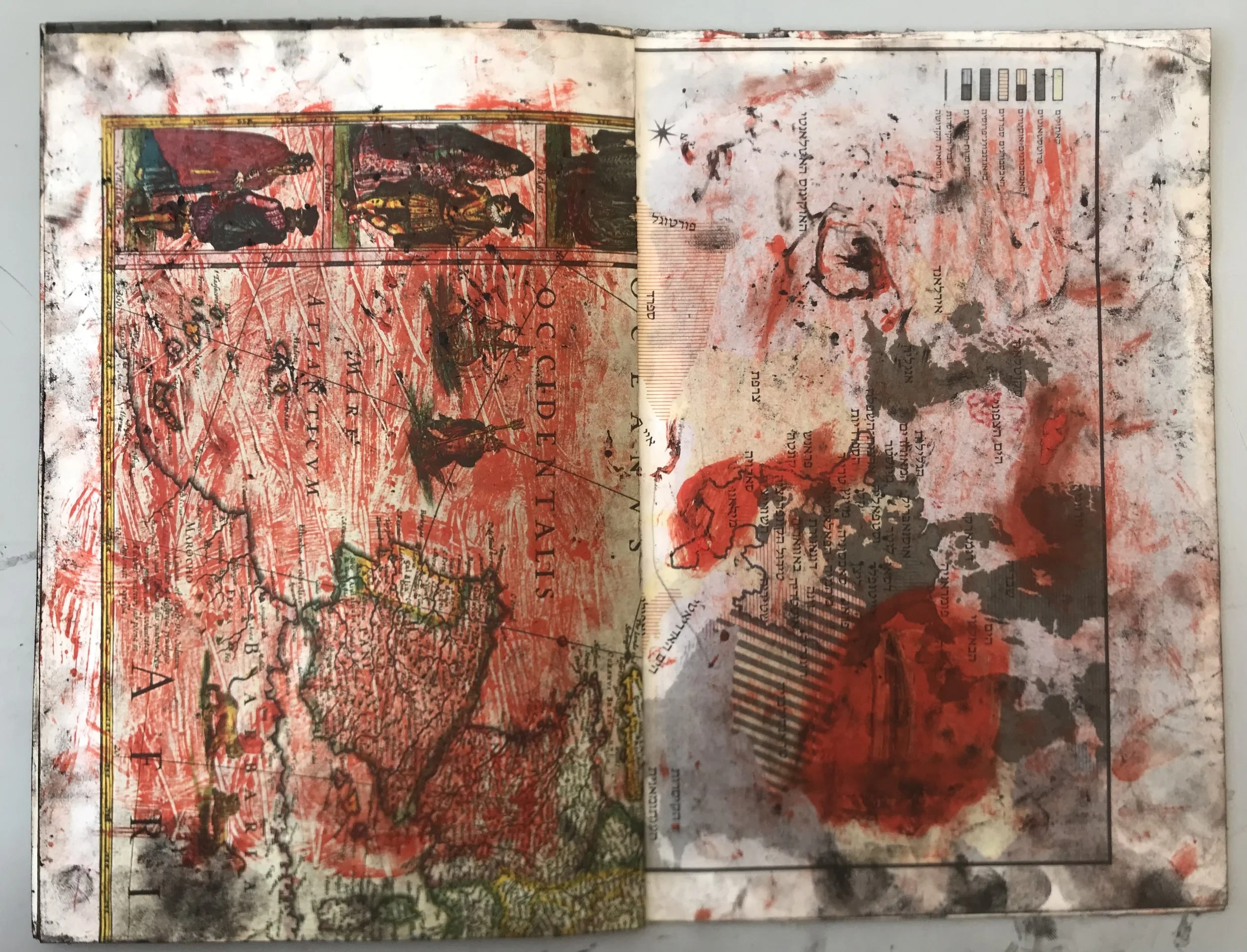 A heavily altered map or artistic collage with red, black, and green paint splatters, overlaid with text, lines, and images, creating an abstract and chaotic appearance.