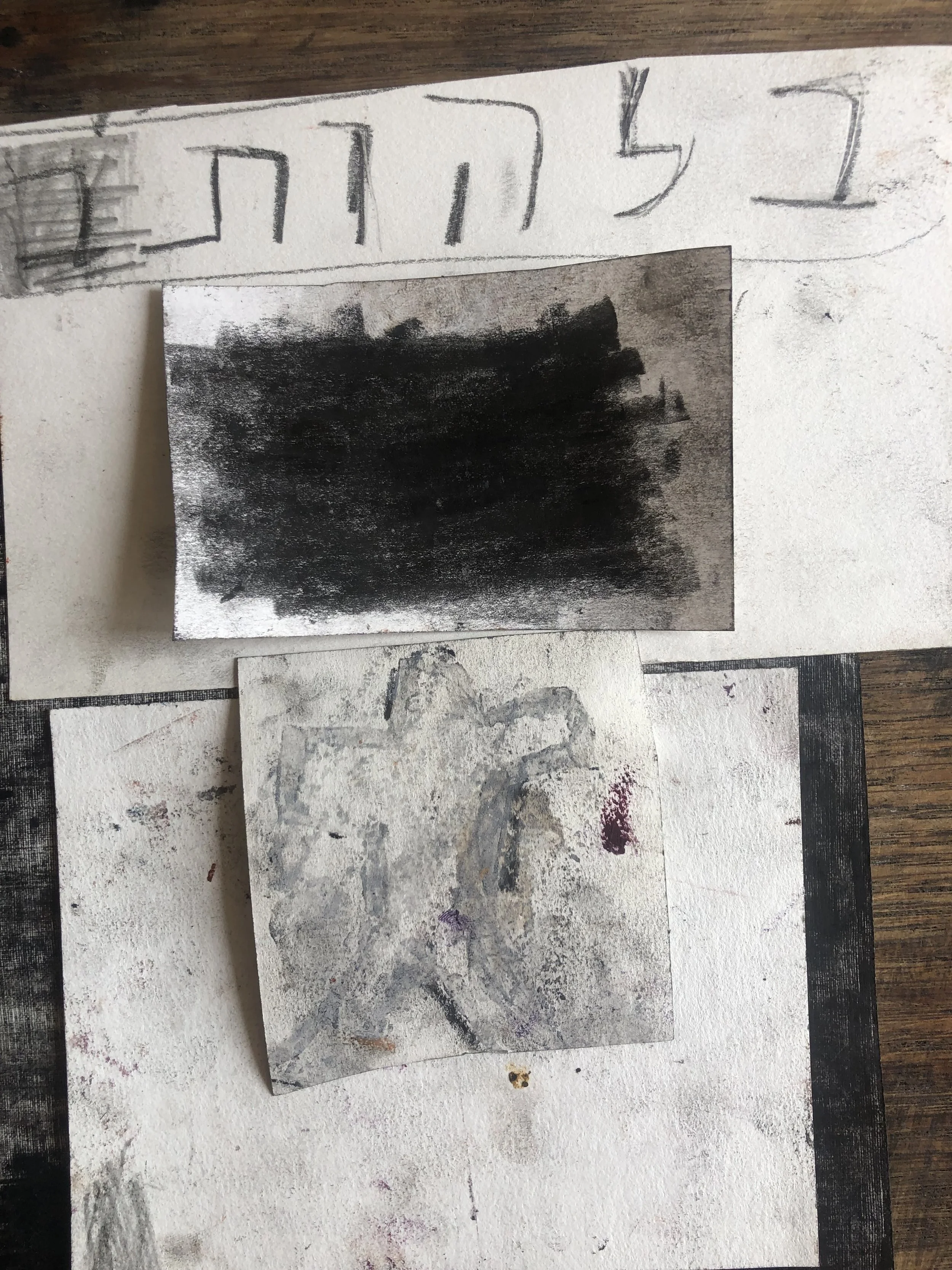 Artwork and sketches on paper, with a blacked-out area, various lines, and scribbles.