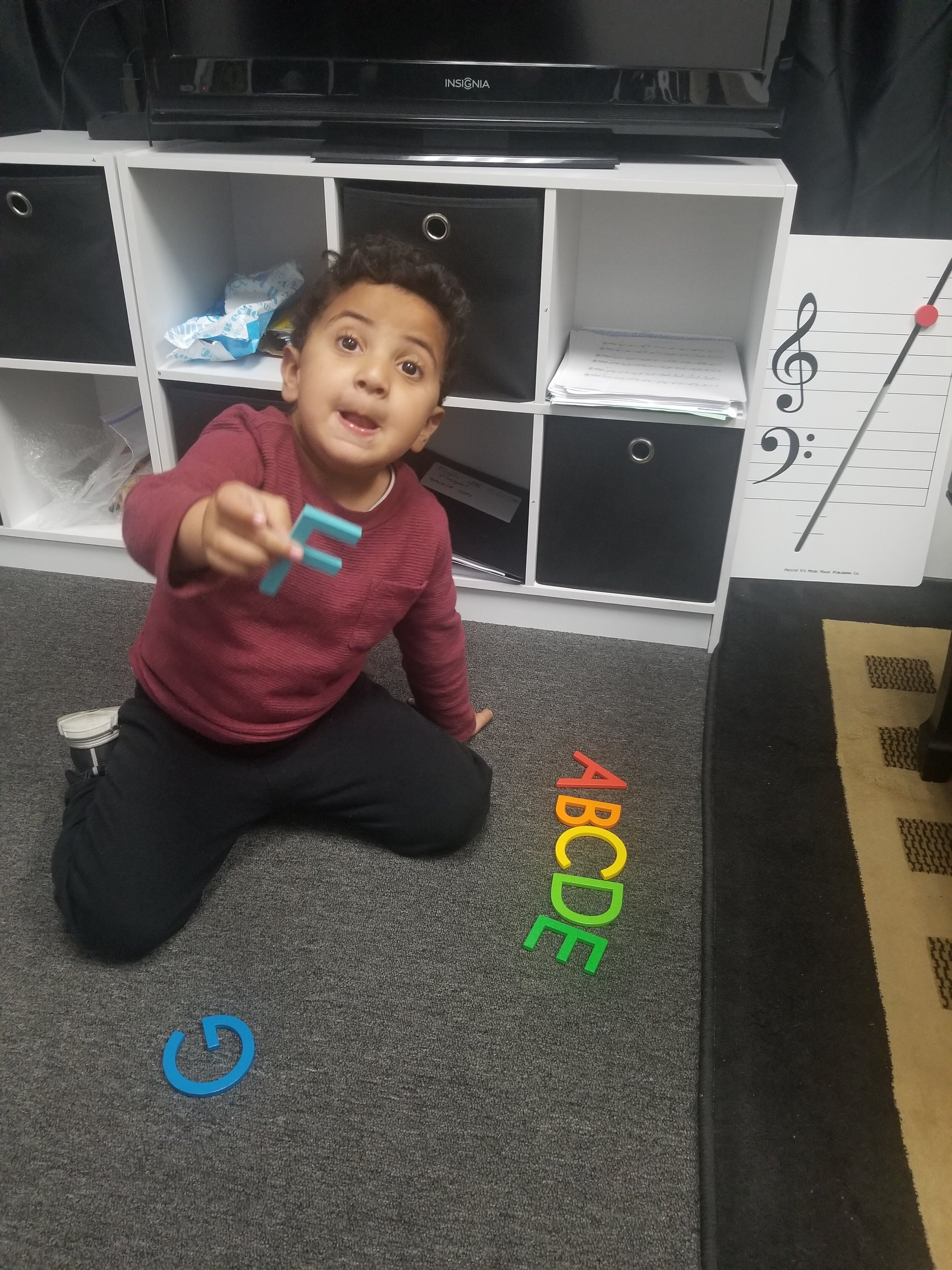 Music Student on floor with music alphabet