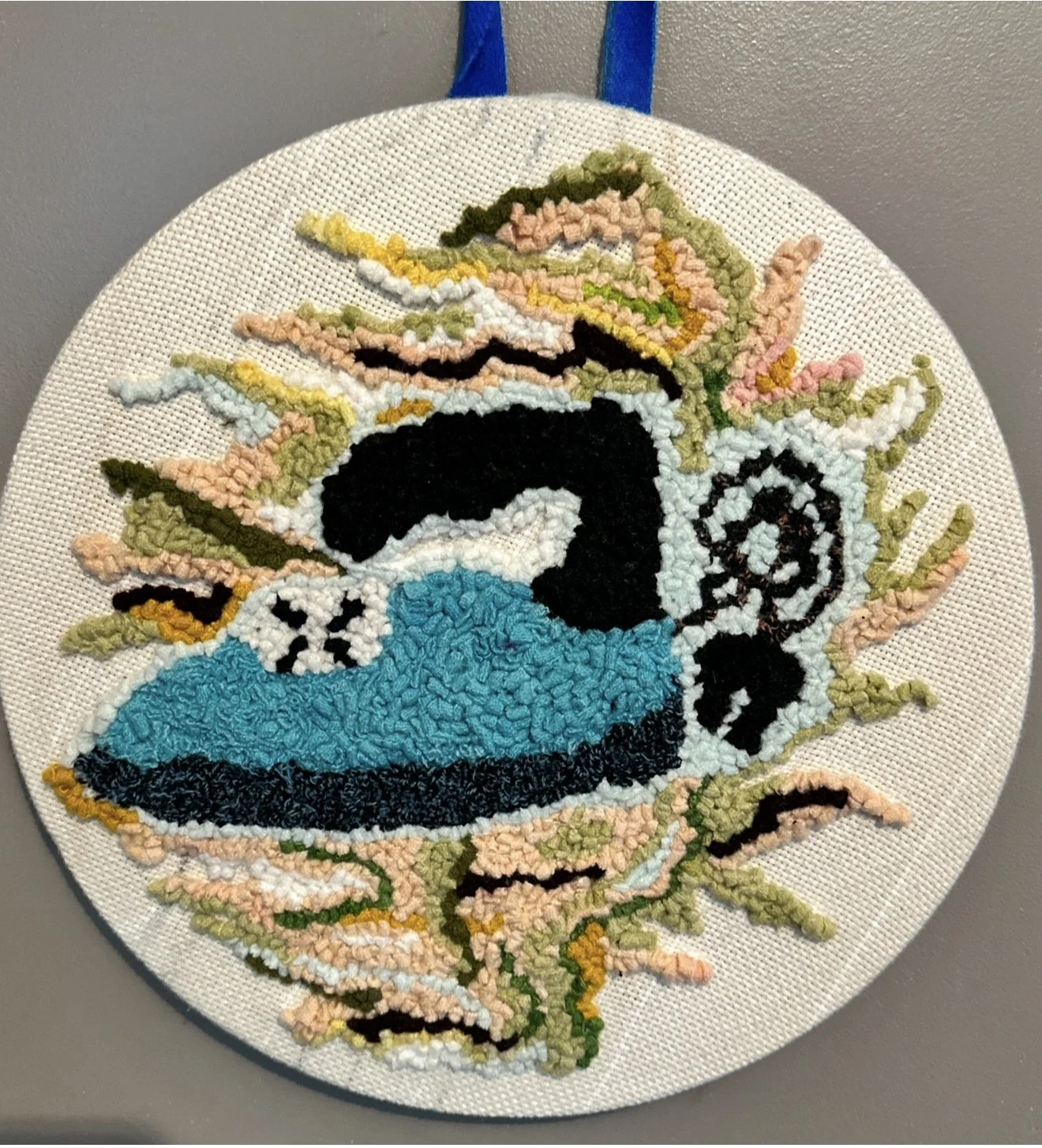 Wall rug decoration/ surrounded by colorful abstract shapes.