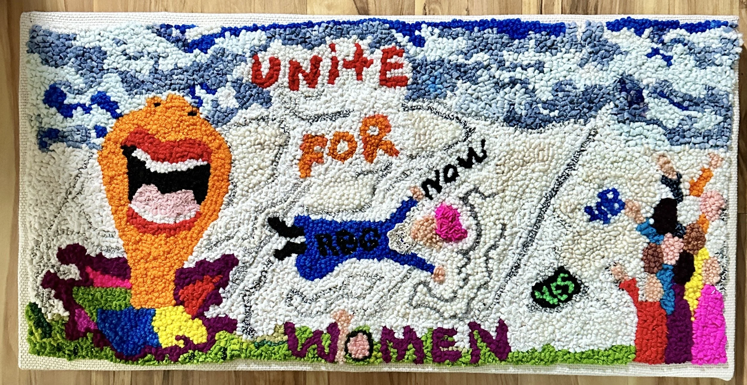 Colorful wool rug with a clown face, a book with the text 'UNITE FOR...' and a candy illustration.