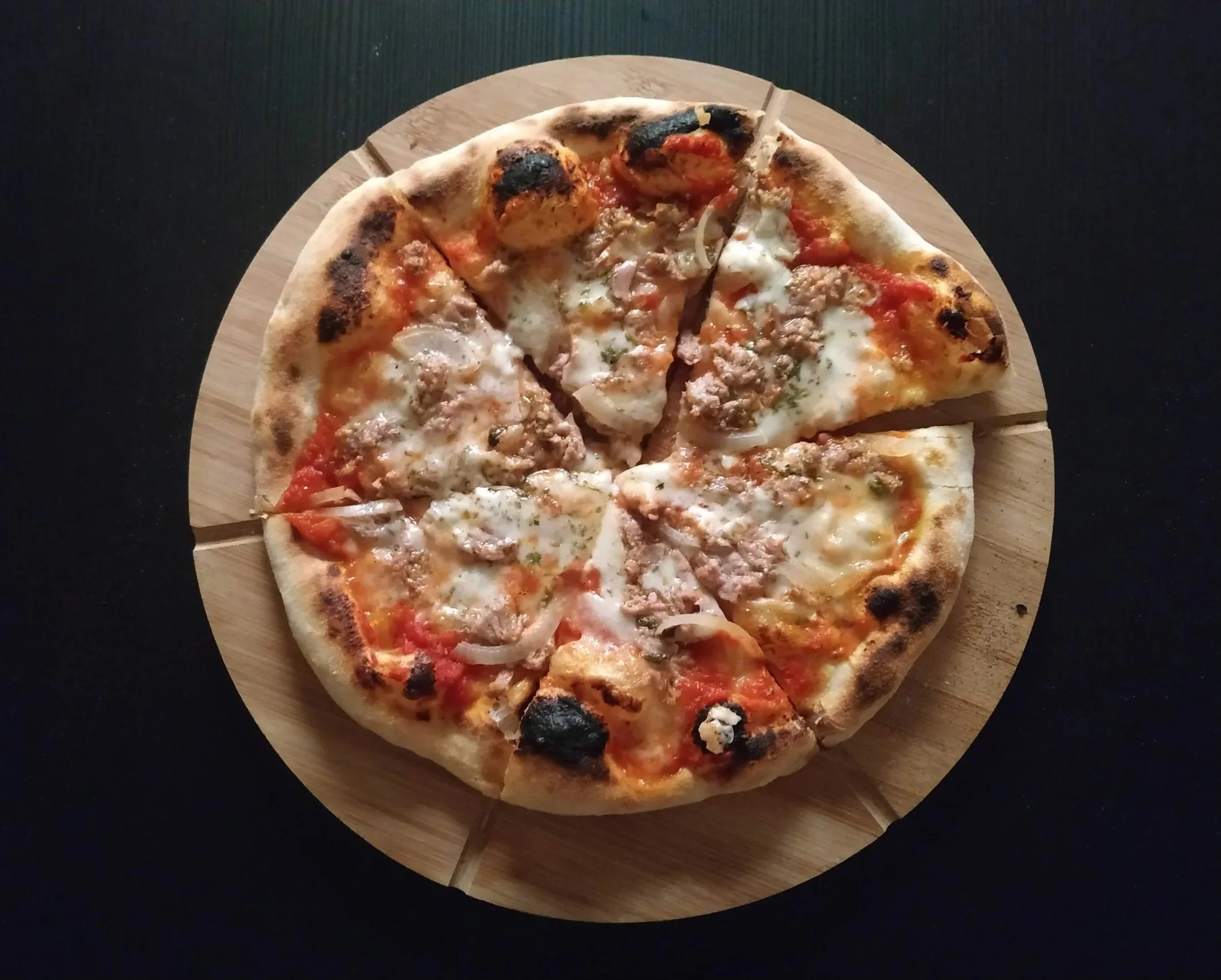 A classic Italian-style pizza topped with mozzarella, served on a wooden board.
