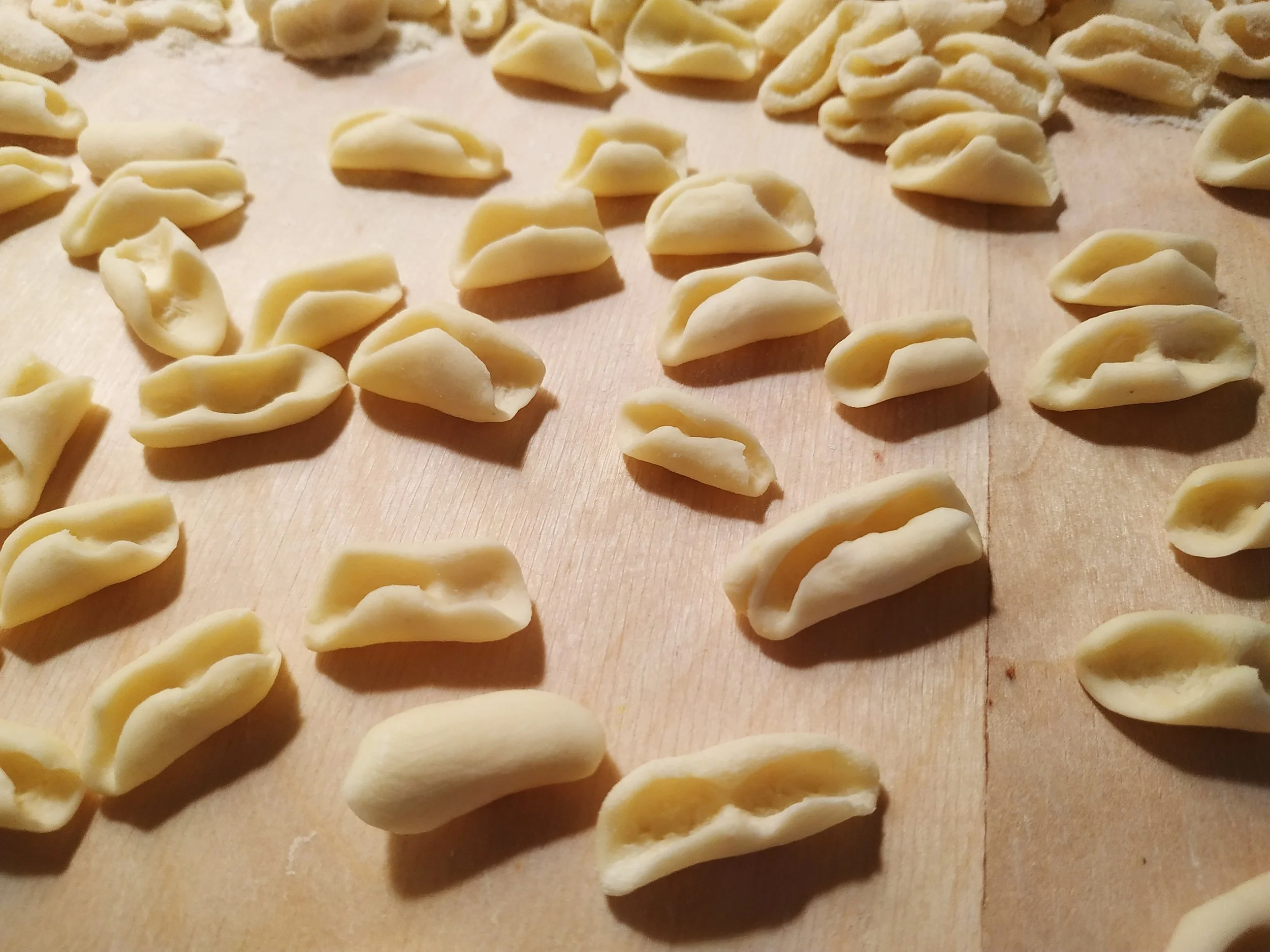 Handmade farfalle arranged on a wooden surface.
