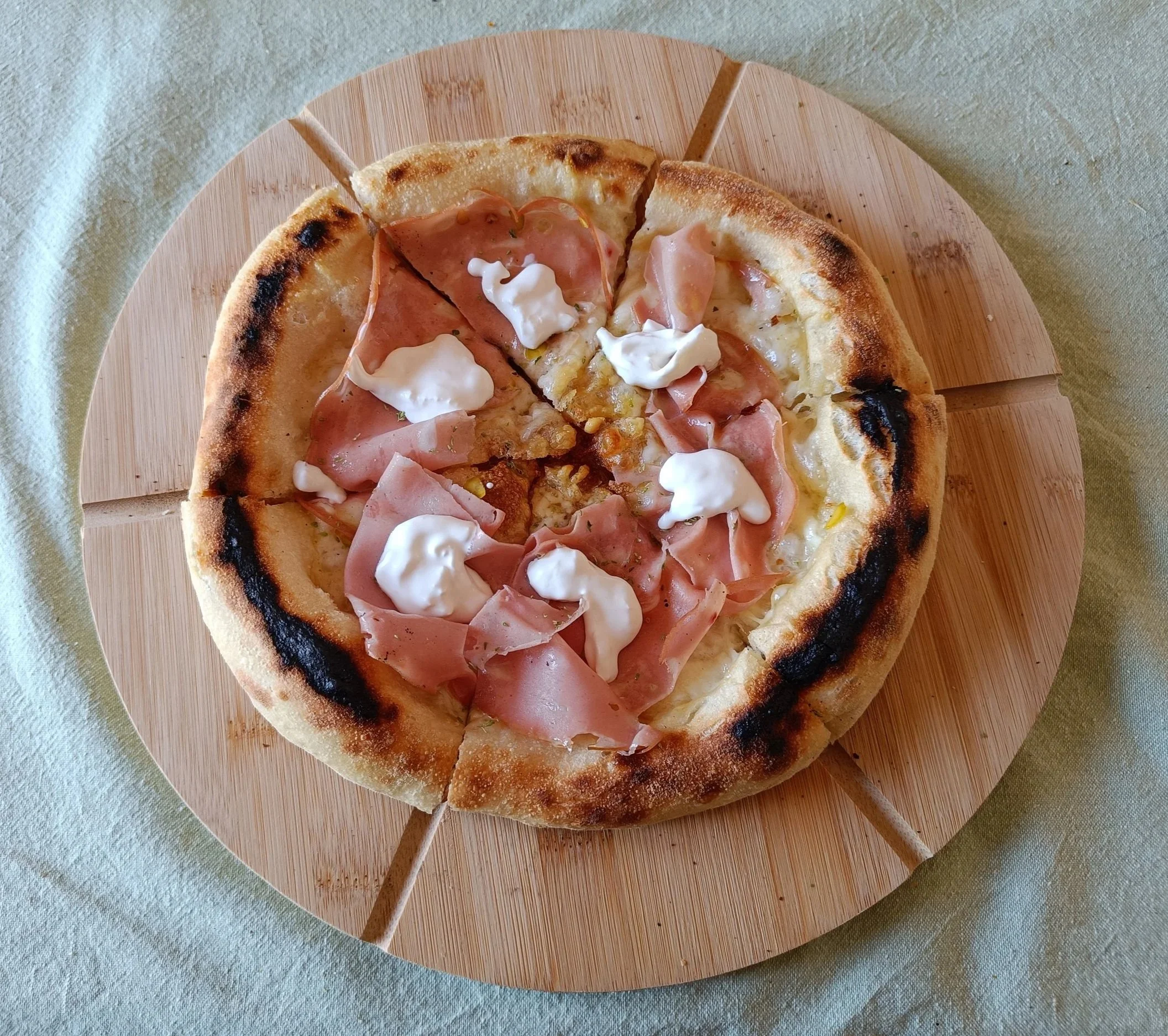 A classic Italian-style pizza topped with tomato sauce, mozzarella, stracciatella, and prosciutto crudo.