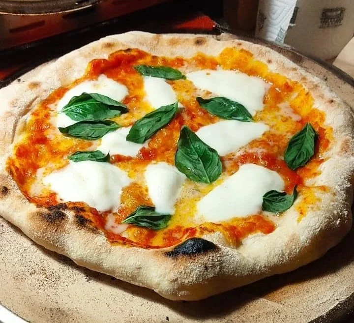 A classic Italian-style pizza topped with mozzarella and fresh basil leaves.
