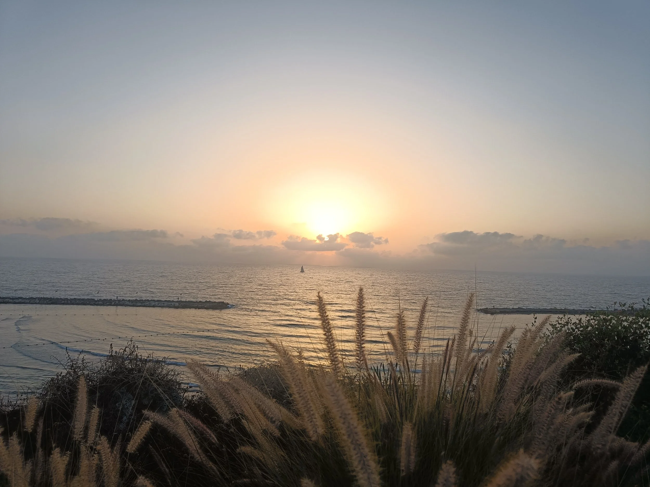 Sunset over the ocean in Costa da Caparica, the coastal home of Coastline Heron.