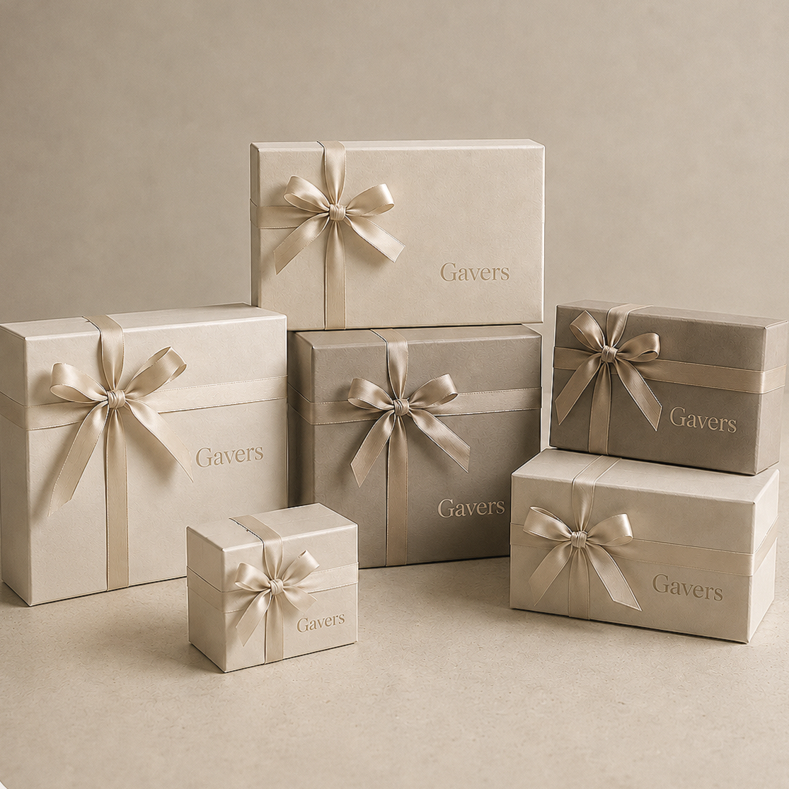 Several beige and gray Gavers gift boxes wrapped with satin ribbons and bows, with the word 'Gavers' printed on some of the boxes, arranged on a neutral background.