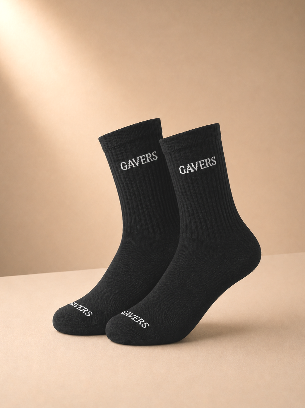 A pair of black socks with the word 'GAVERS' written in white on both the top and the foot.