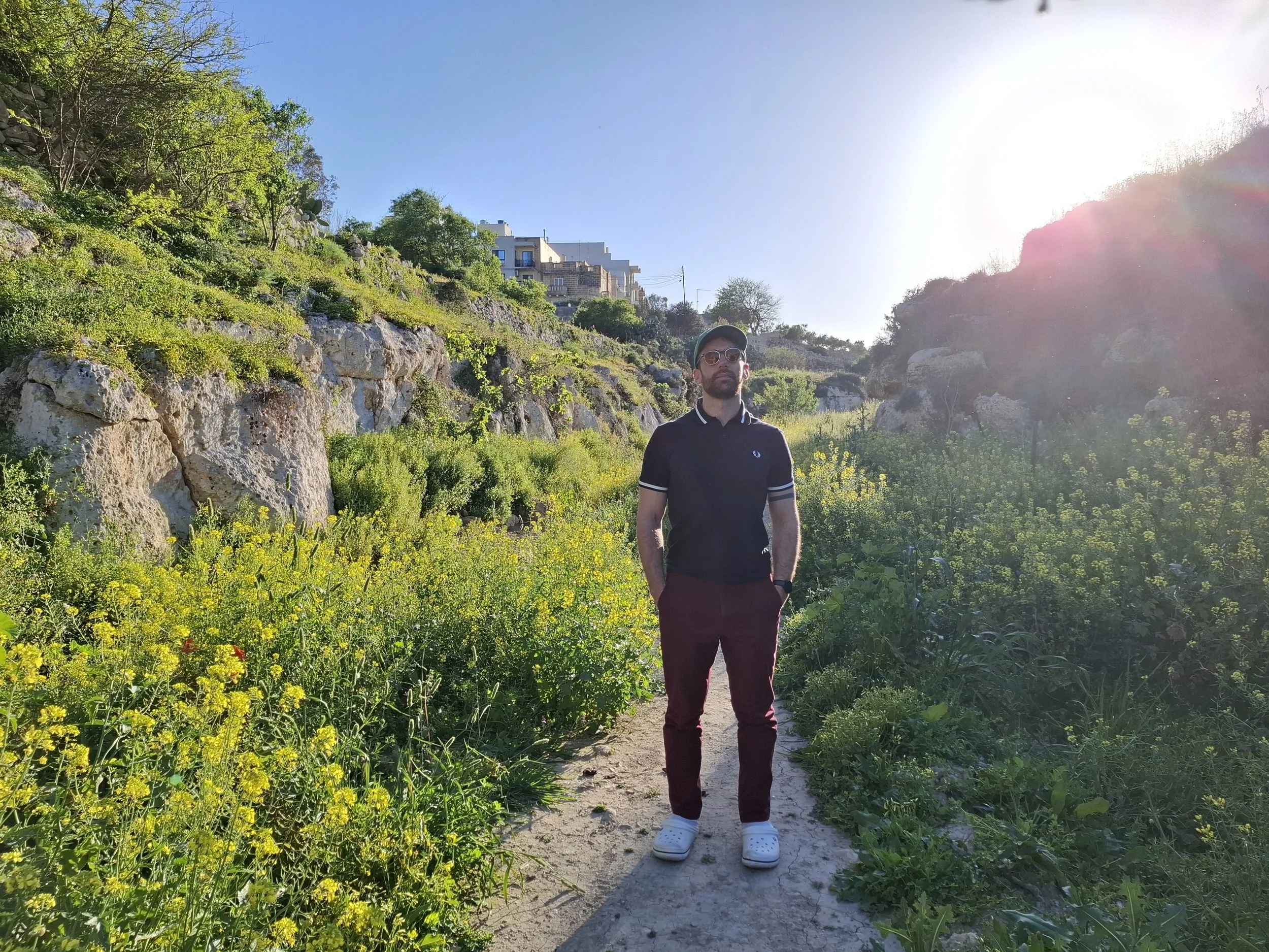 Man stands at the start of a green valley