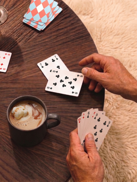 Man playing cards and drinking hot chocolate