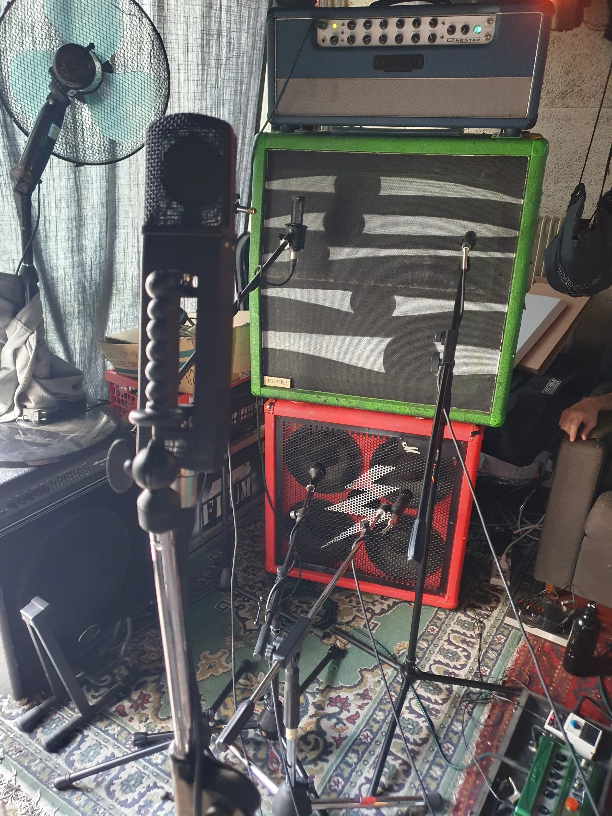 Attrezzature musicali in uno studio di registrazione, inclusi amplificatori, microfoni, microfono a immagini, giradischi, e altri accessori musicali.