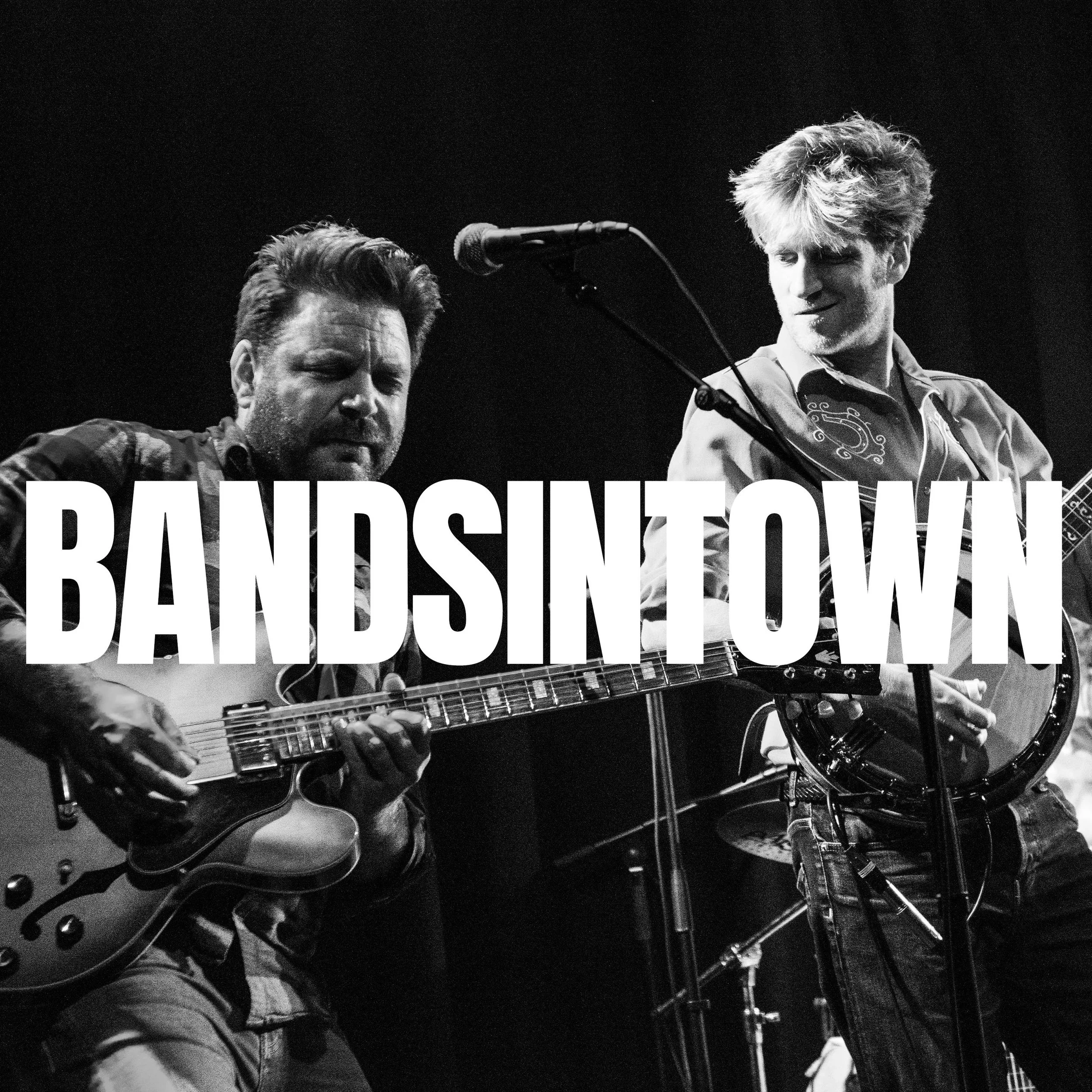 Black-and-white photo of two men performing music on stage, with one playing a guitar and both with their eyes closed. A microphone is in front of them, and large text overlay reads 'BAND OF HOPE'.