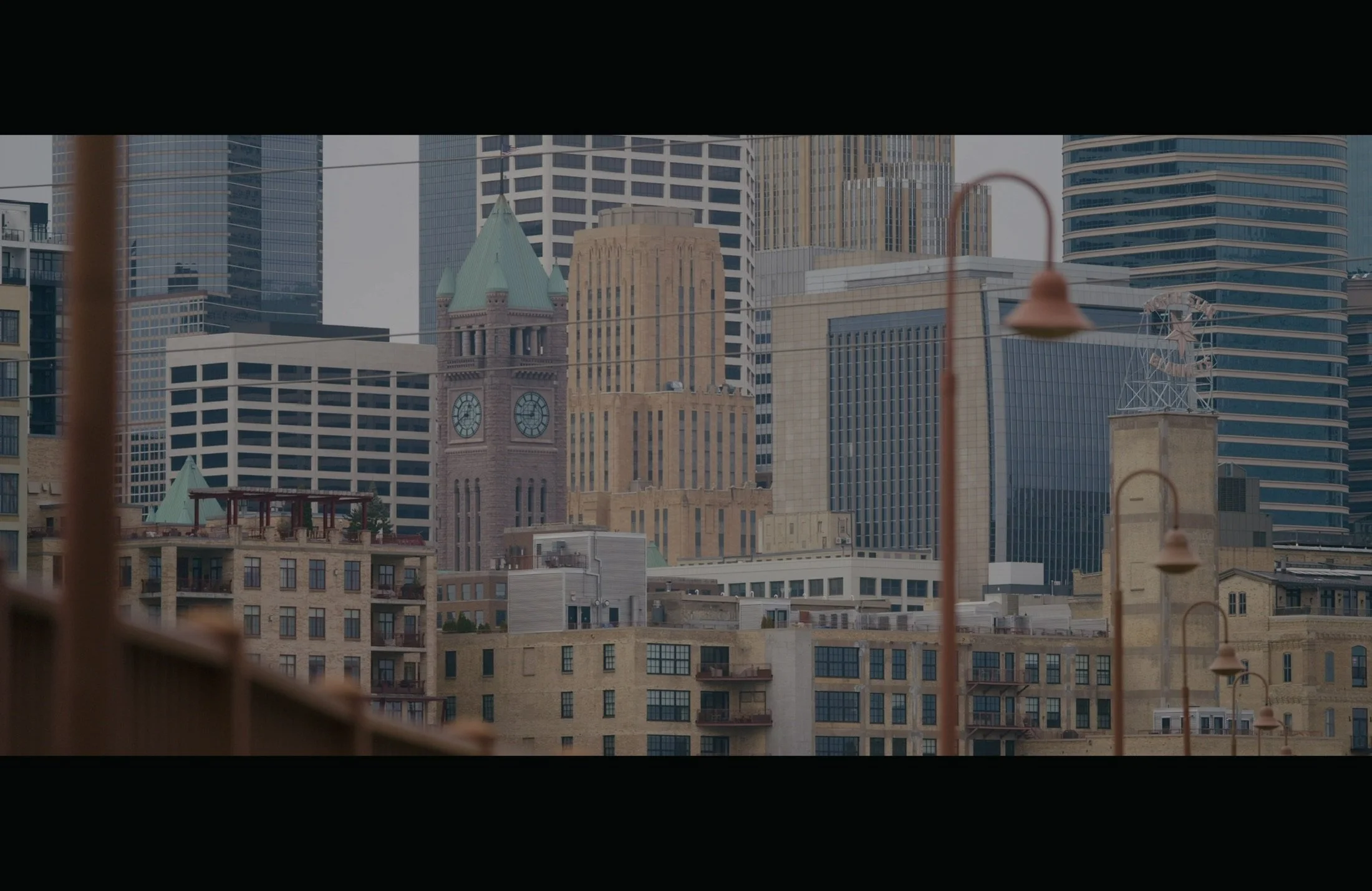 City skyline with a mix of historic and modern skyscrapers, including a clock tower and various high-rise buildings.