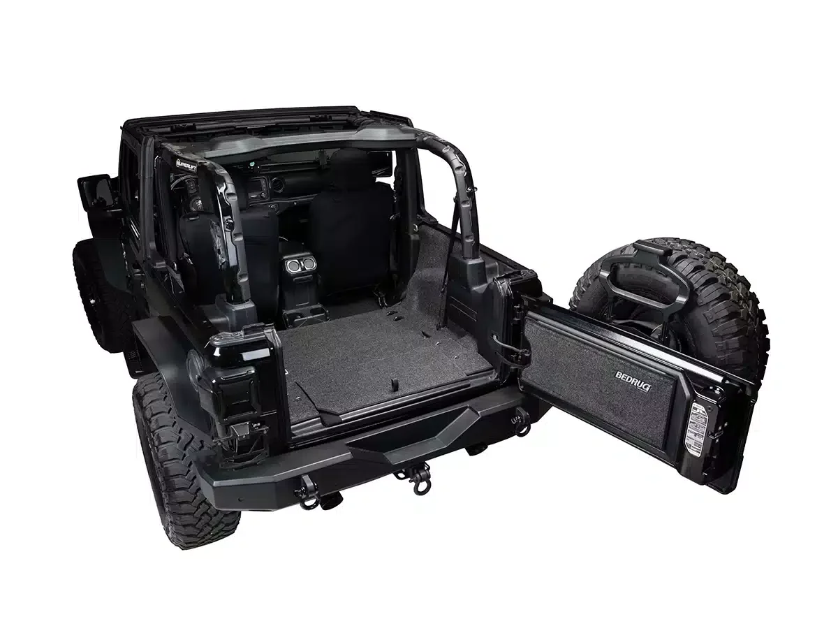 Empty off-road vehicle's frame with removed doors and seats, showing interior and spare tire.