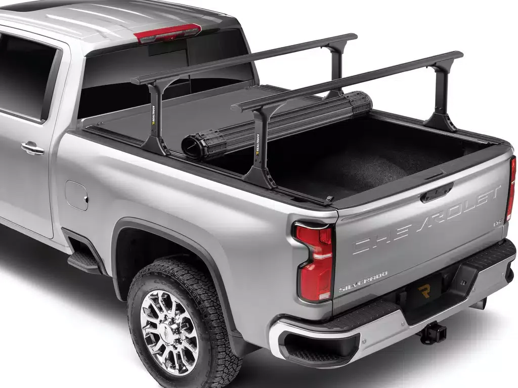 Silver Chevrolet Silverado pickup truck with an empty truck bed equipped with a bike rack and a flashlight mounted on the rack.