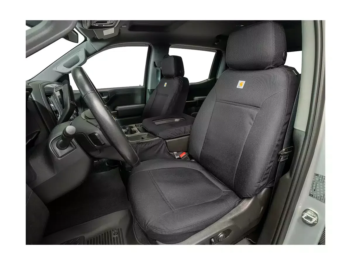 Front interior of a vehicle showing driver and passenger seats with black seat covers, steering wheel, and dashboard.