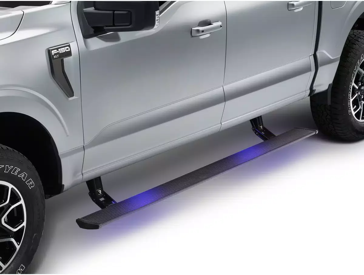 Close-up of the side of a silver Ford F-150 truck, showing the side step with blue LED lights underneath the door.