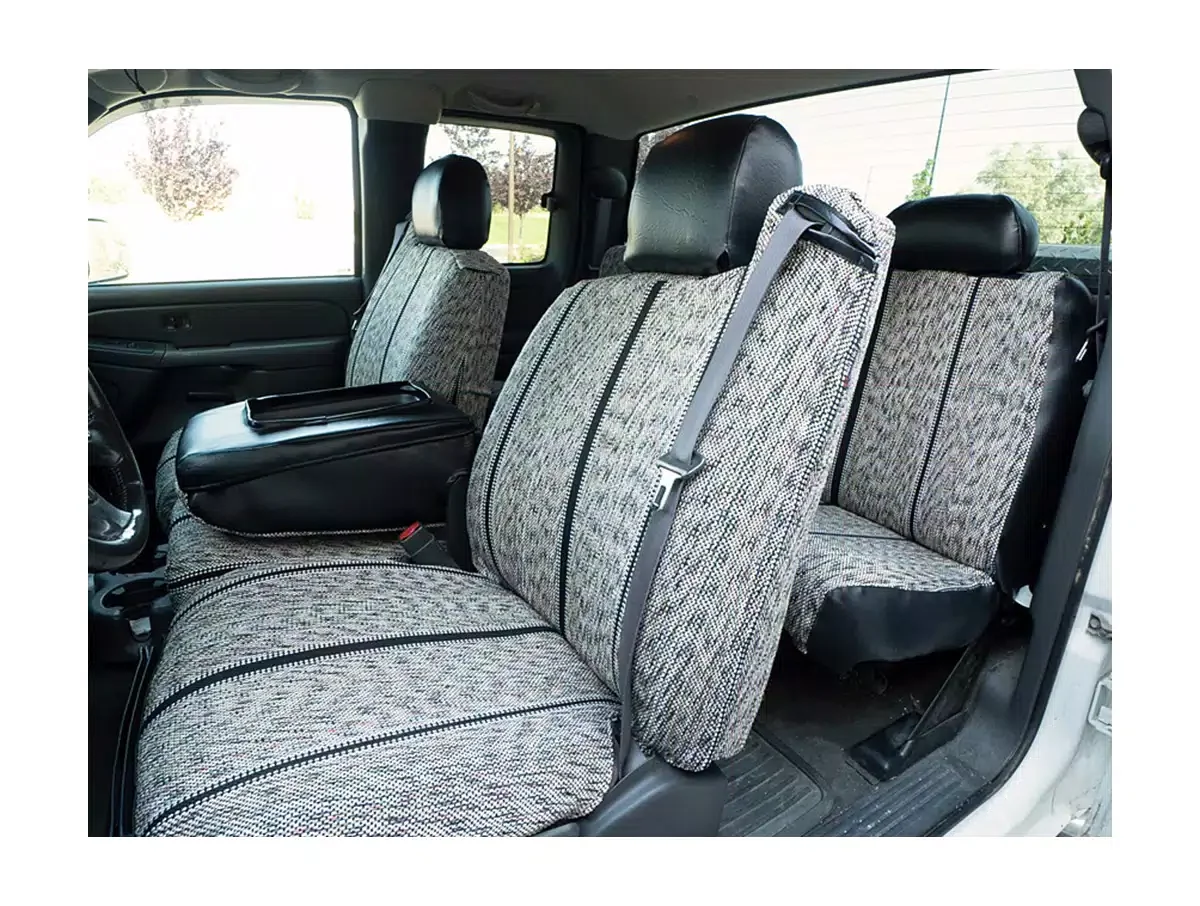 Interior of a vehicle showing patterned fabric seats with headrests, seat belts, and a black armrest on the front passenger seat.