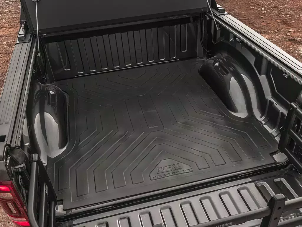 Empty truck bed with a black rubber liner and a fold-down tailgate.