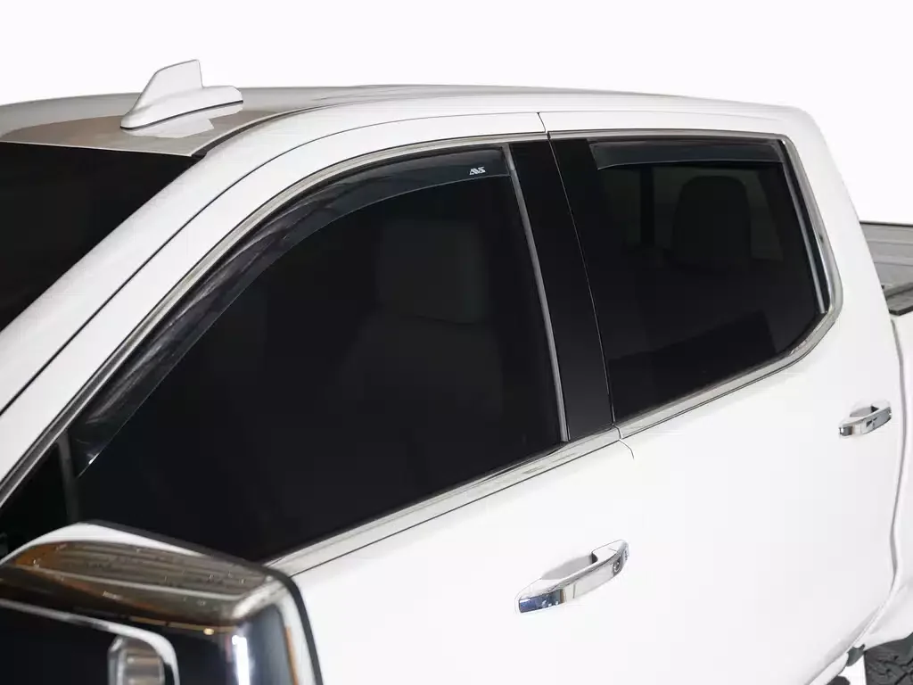 Close-up of the upper side of a white pickup truck showing tinted side windows, door handles, and a shark fin antenna.