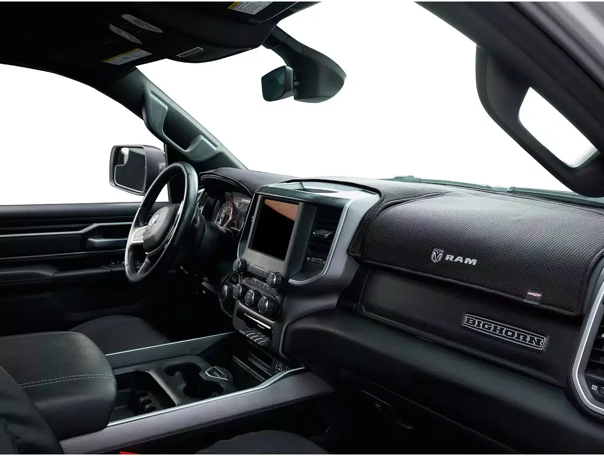 Interior dashboard of a RAM Bighorn truck with steering wheel, digital display, control knobs, and RAM logo.