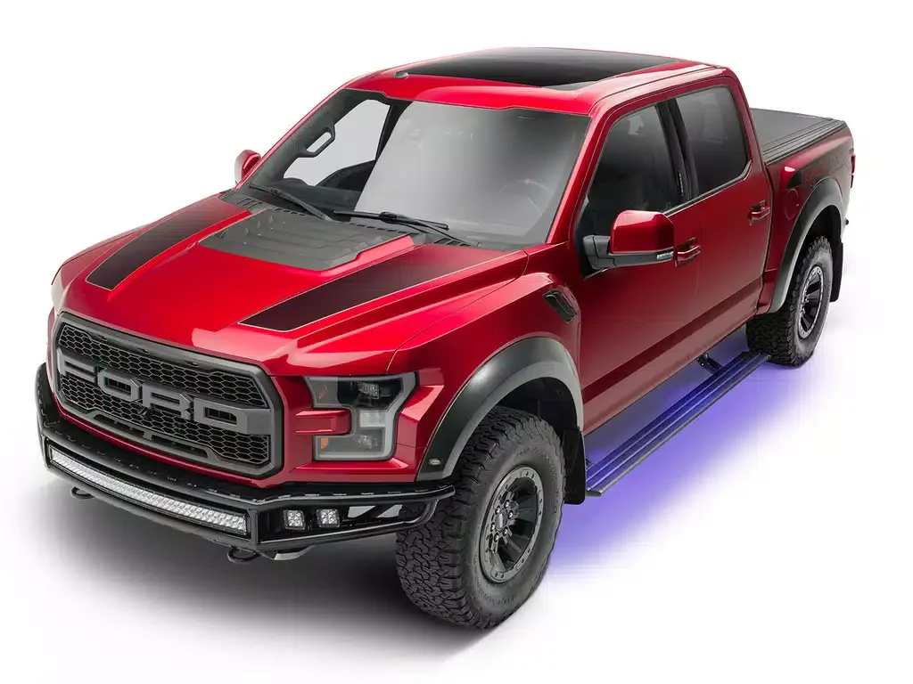 Red Ford pickup truck with black accents, large off-road tires, and underglow lighting.