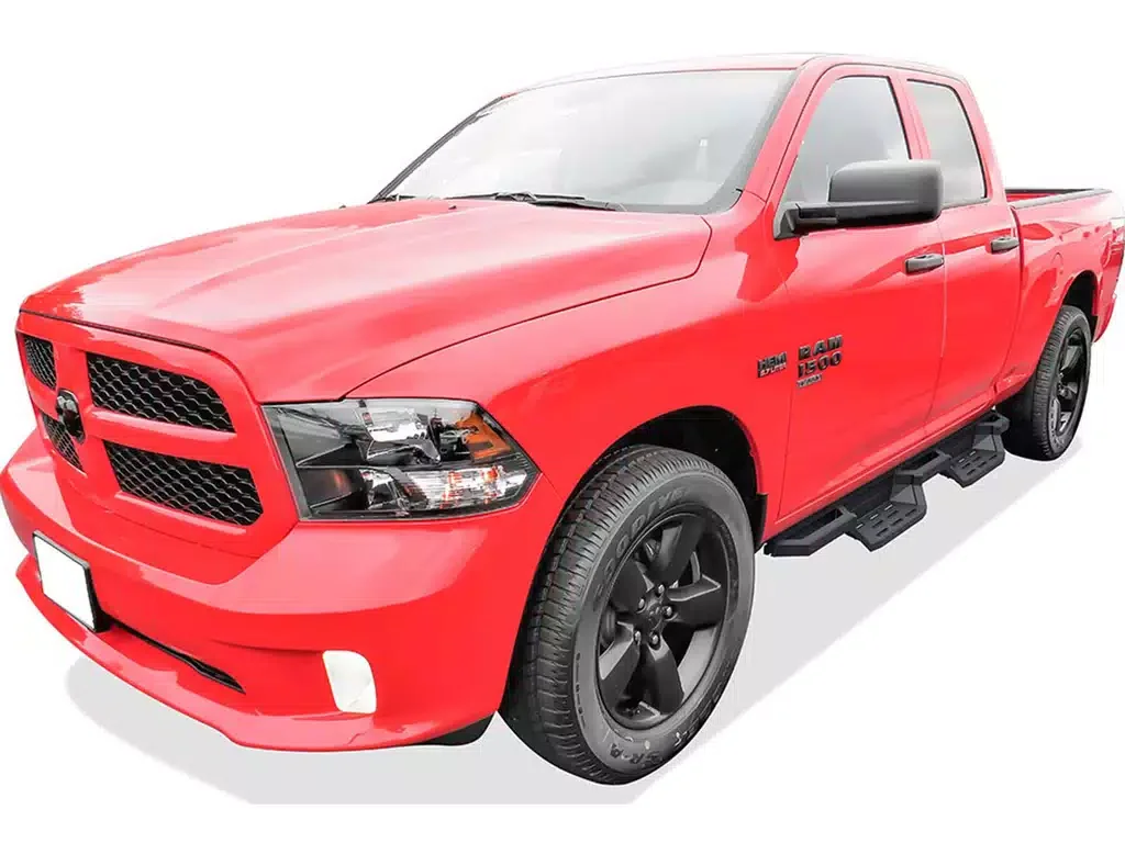 A red Dodge Ram 1500 pickup truck with black wheels and side steps, viewed from the front left.