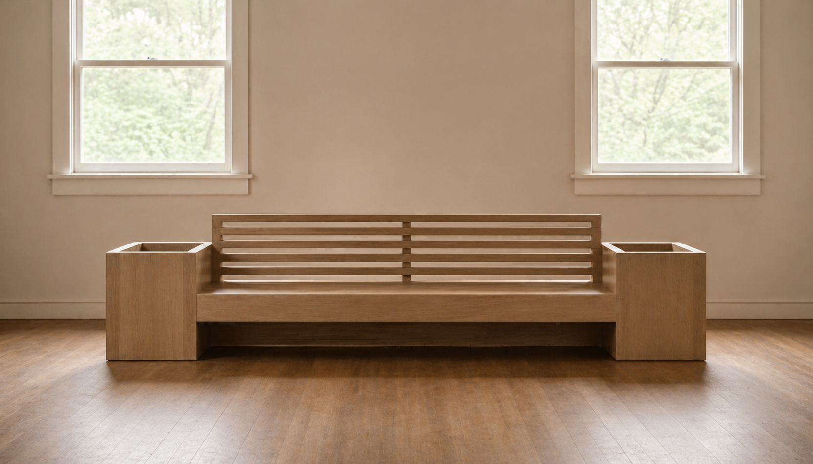 Empty wooden bench with armrests placed in a room with two large windows, beige walls, and wooden floor.