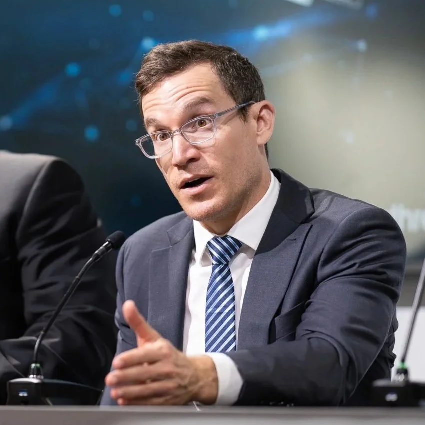 Dr. Derman in glasses and a suit speaking during a panel discussion.