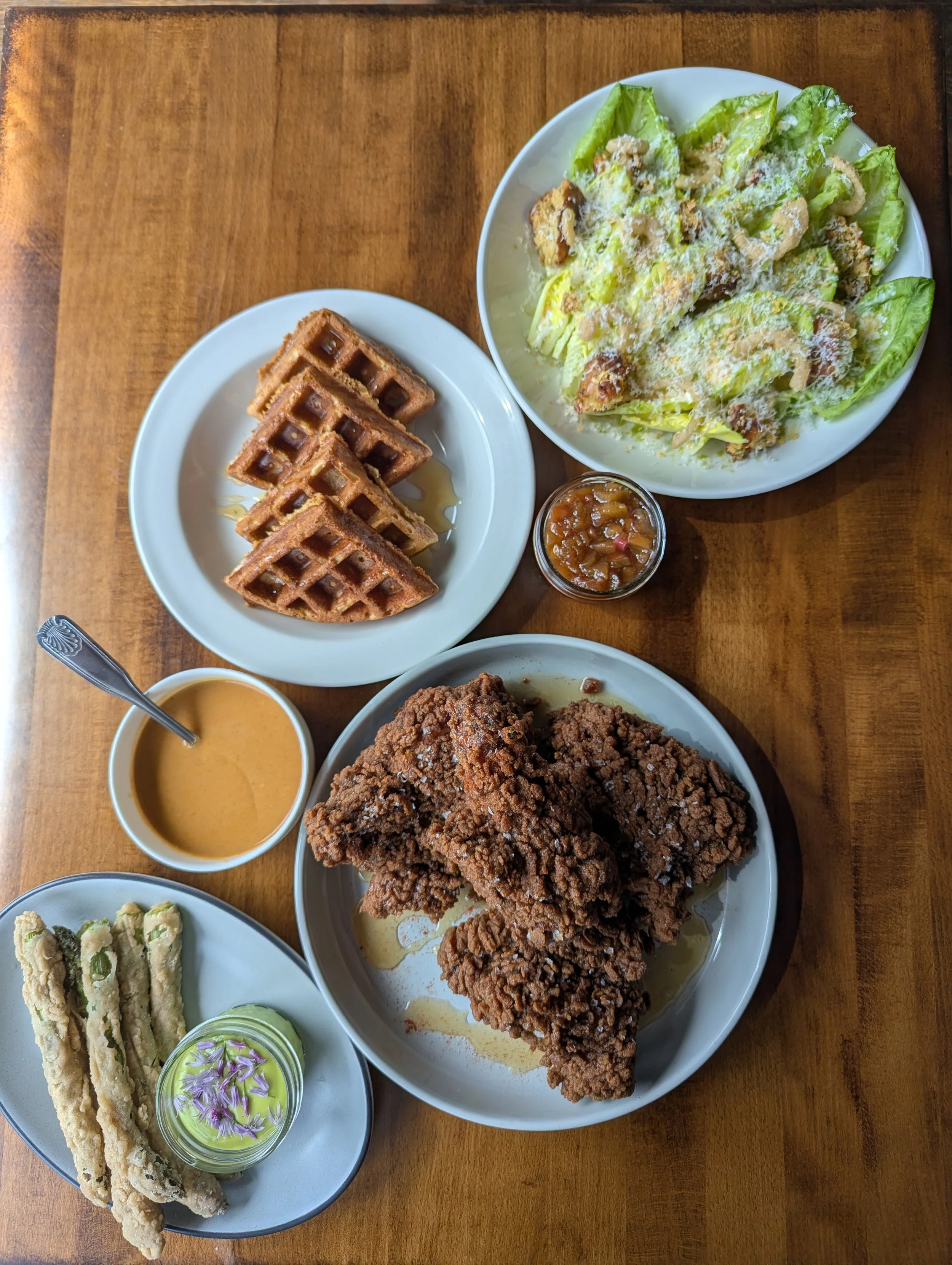 Top down photo of fried chicken, corn waffles, and accompaniments