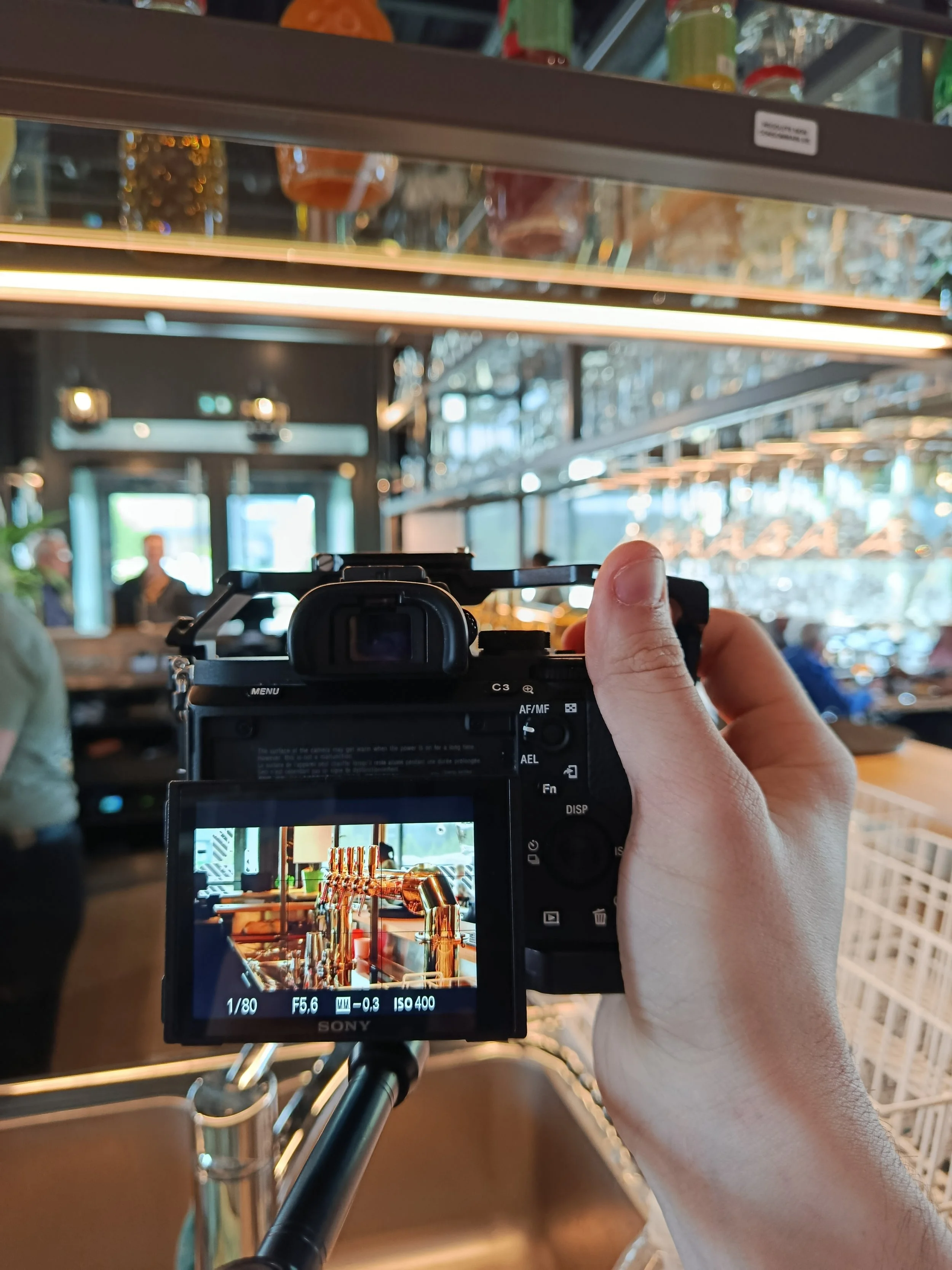Photo d'un appareil photo numérique montrant une image numérique d'une décoration de cuivre suspendue avec des bouteilles en verre en arrière-plan dans un restaurant ou une cafeteria