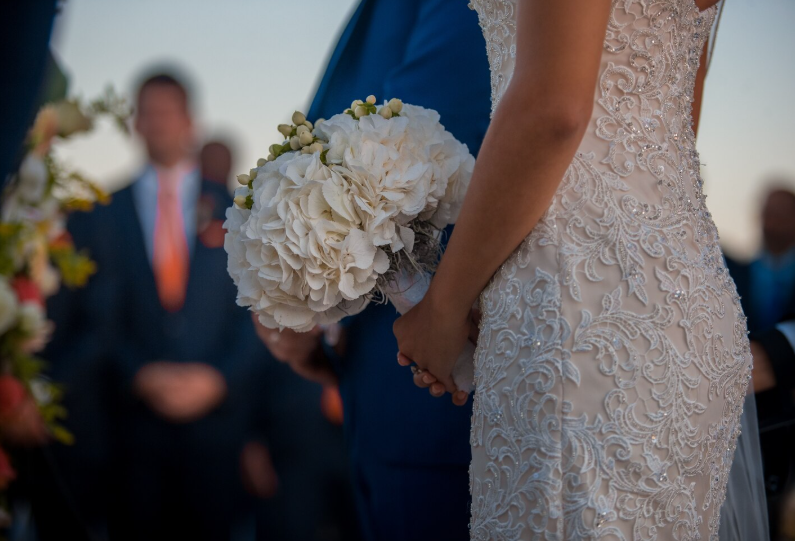 Une mariée tenant un bouquet de fleurs blanche lors d'un mariage